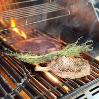 a piece of beef cooking on a barbecue