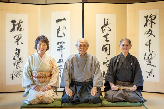 境野氏が揮毫した屏風の前で