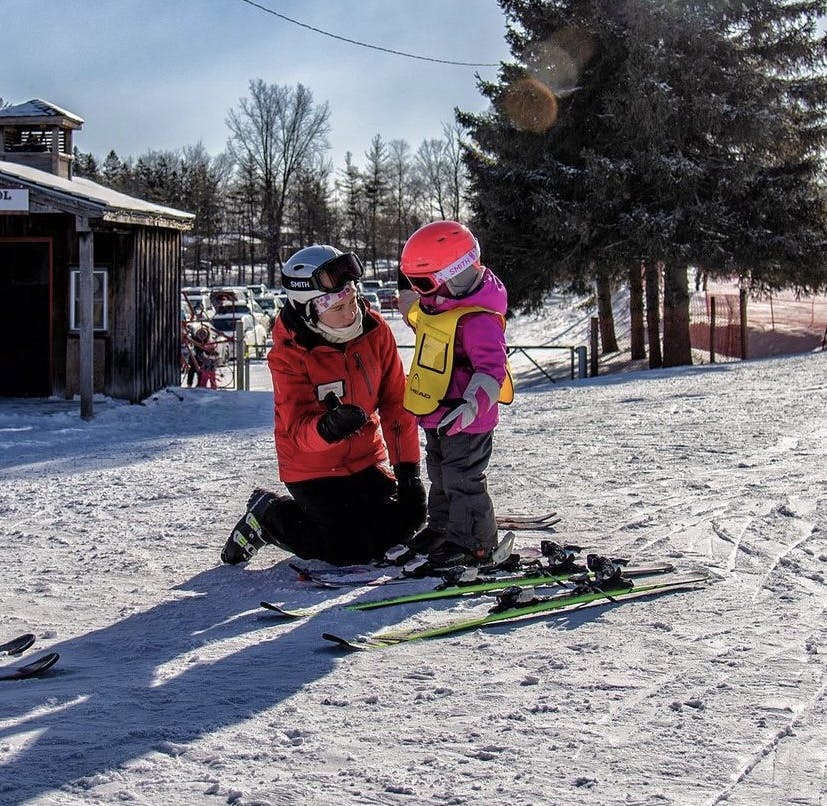 Instructor explaining the basics of skiing to a new young student