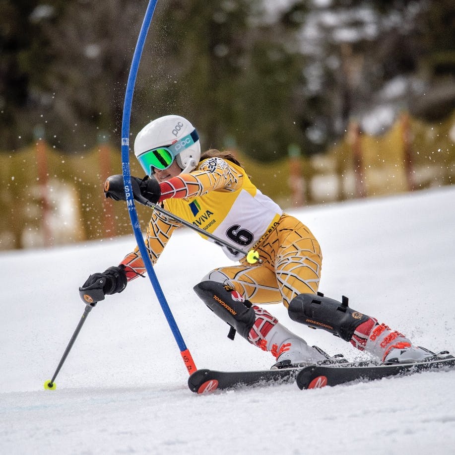 Racer on ski's dodging a pole