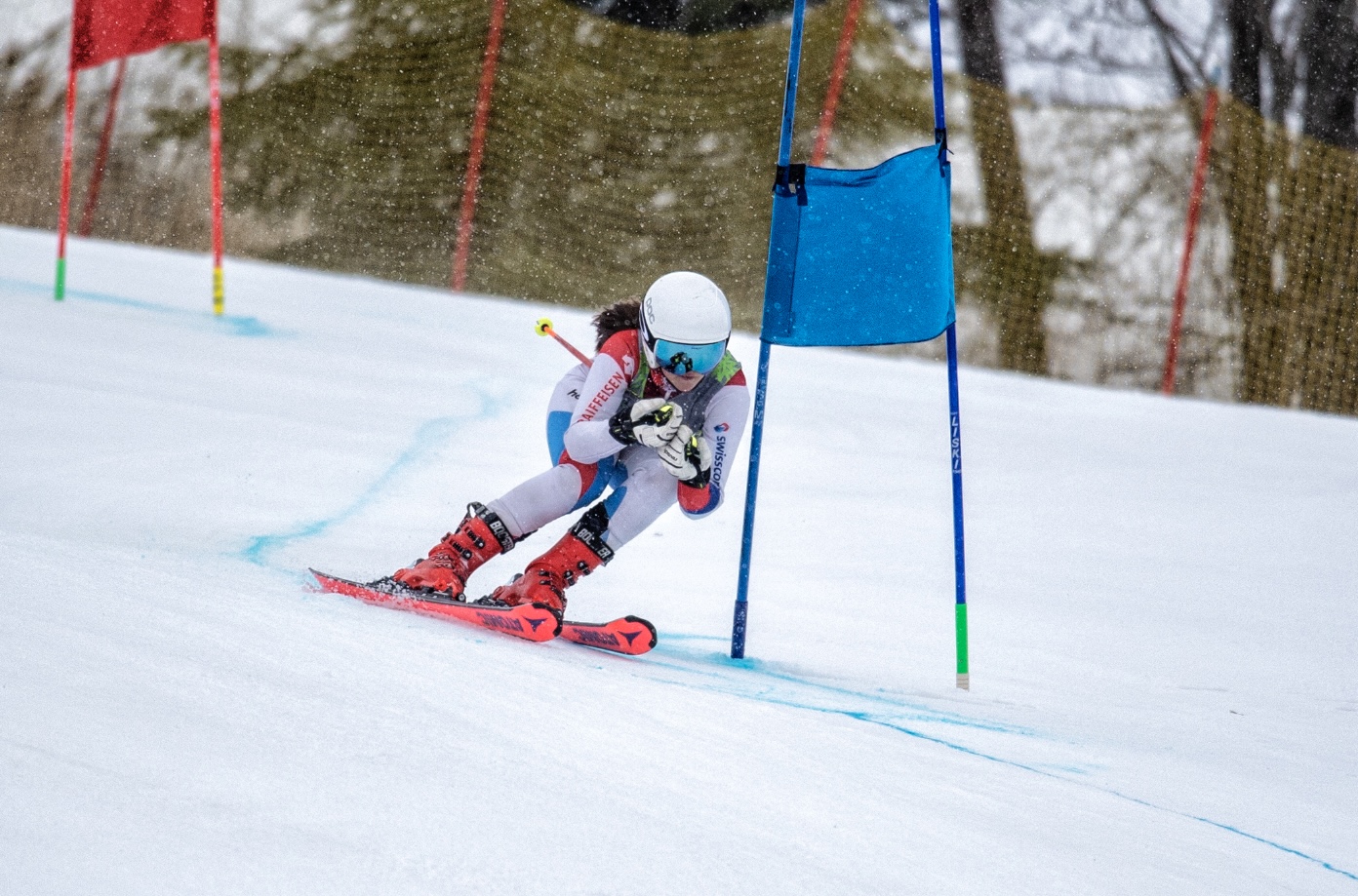 Older racer skiing down hill through flags