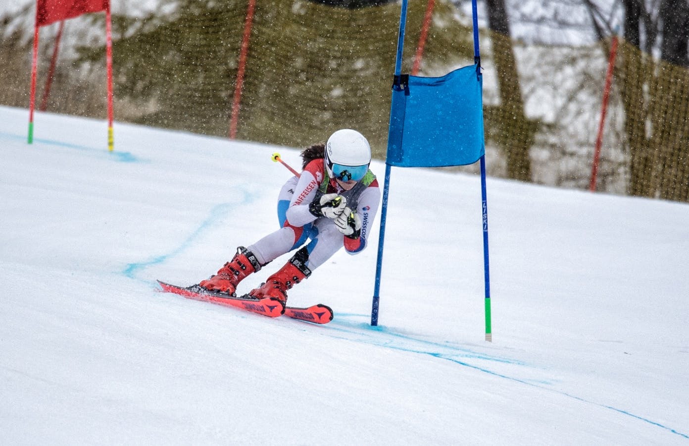 Older racer skiing down hill through flags