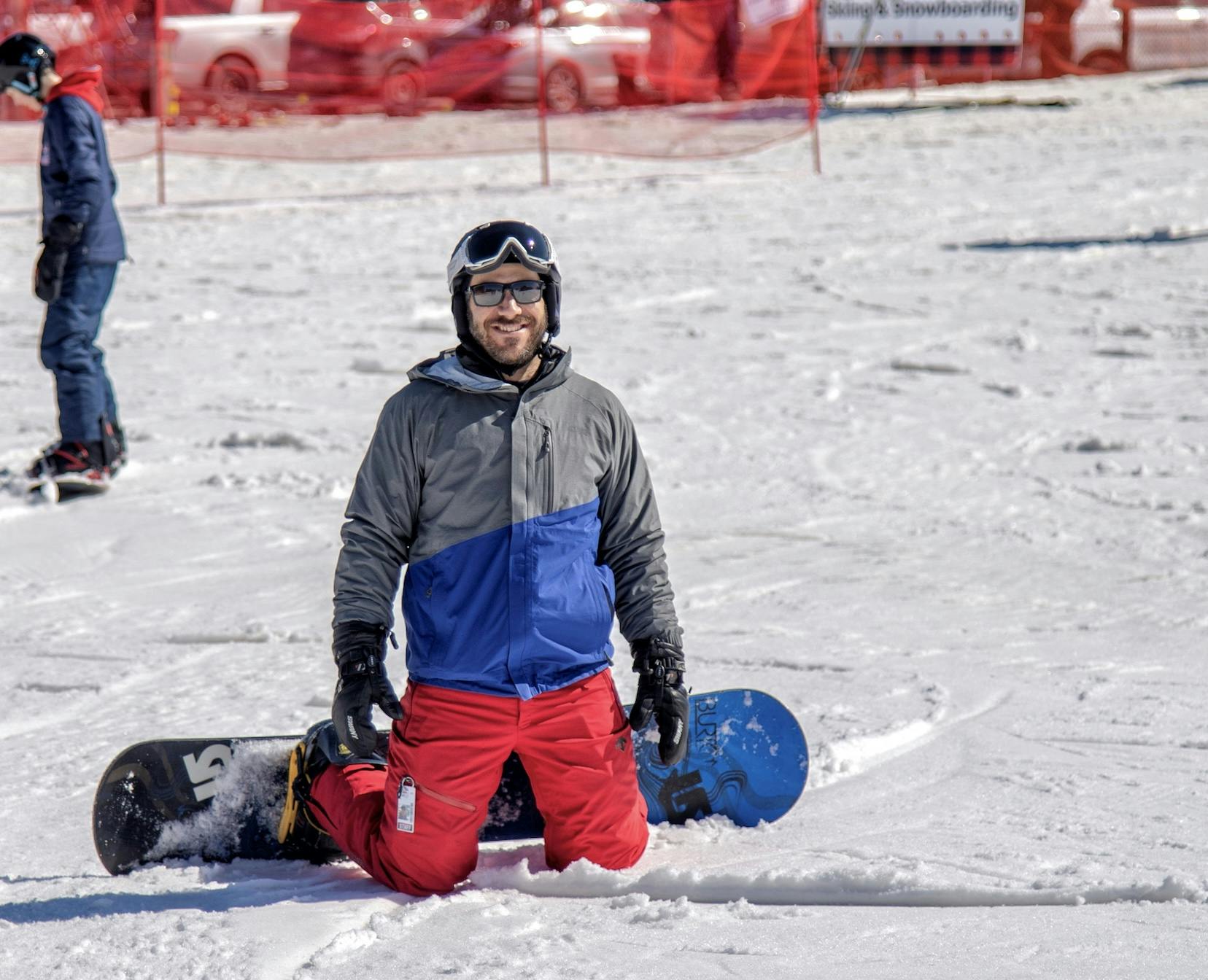 Older snowboarder getting up and getting ready to ride down the hill