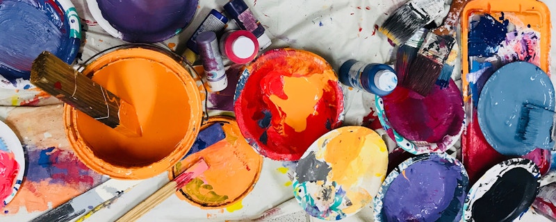 Various open cans of paint in an artists studio 