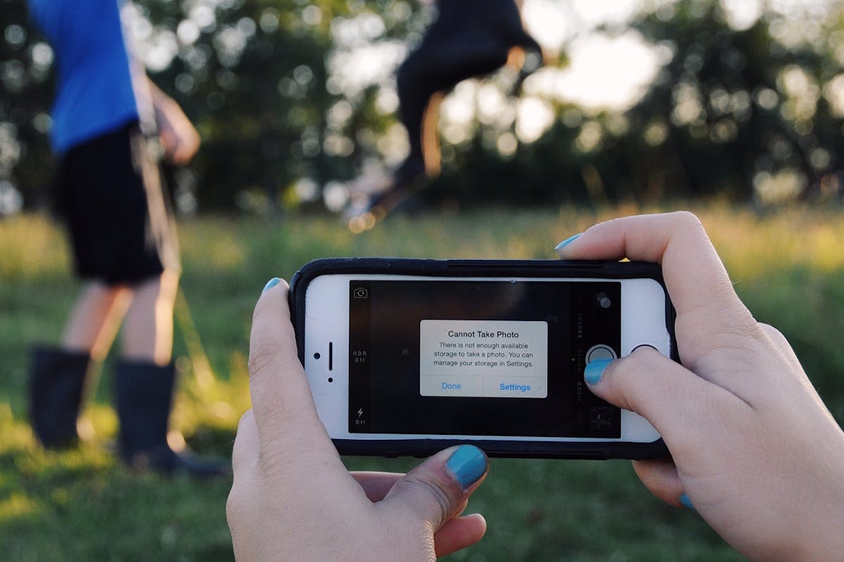 a woman is trying to take a photo on her i-phone and her storage is full