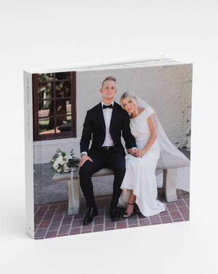wedding photo album of couple sitting on bench on wedding day