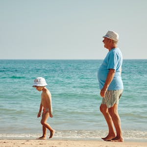 Grandfather and grandson walking on a beach together
