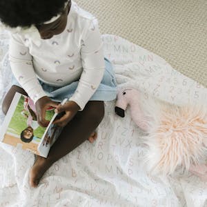 child sitting on the floor looking at a photo book