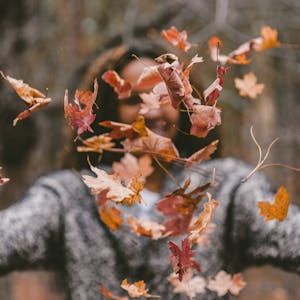 girl throwing leaves