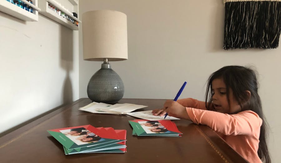 Little girl writing Christmas cards