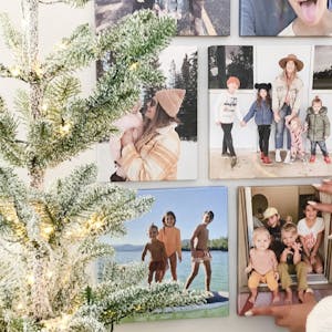 gallery wall layout of canvas prints with woman's hand sticking one to wall
