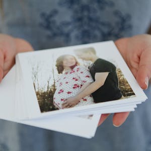 husband and wife posing with baby bump in a printed photo