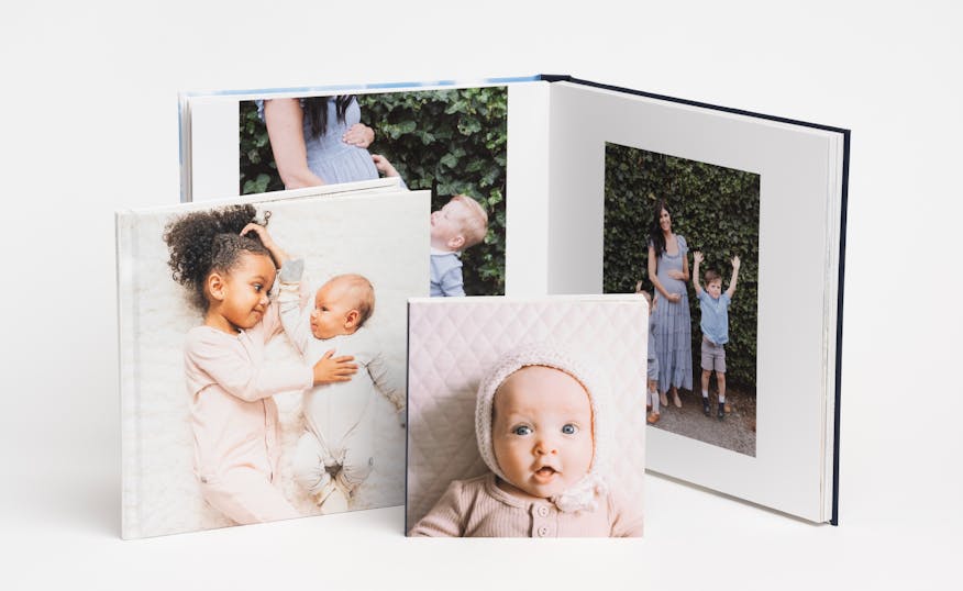 a collection of family photo books showing a baby on the cover and a family on premium pages