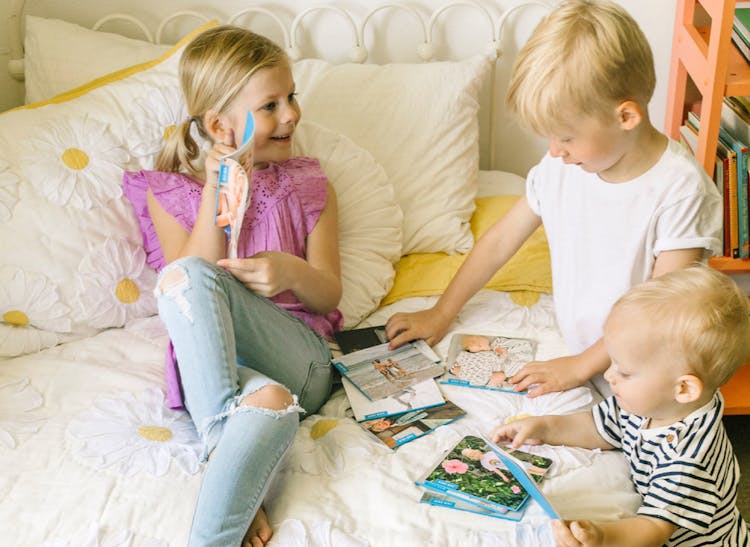 toddler and young girl looking at monthly family photo albums