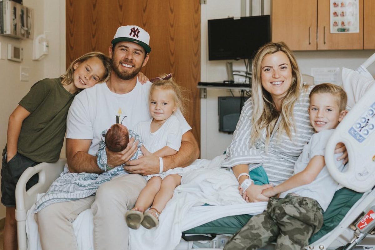 family in hospital bed with newborn baby