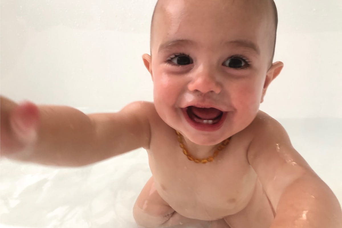 baby in a minimalistic white bathtub and bathroom