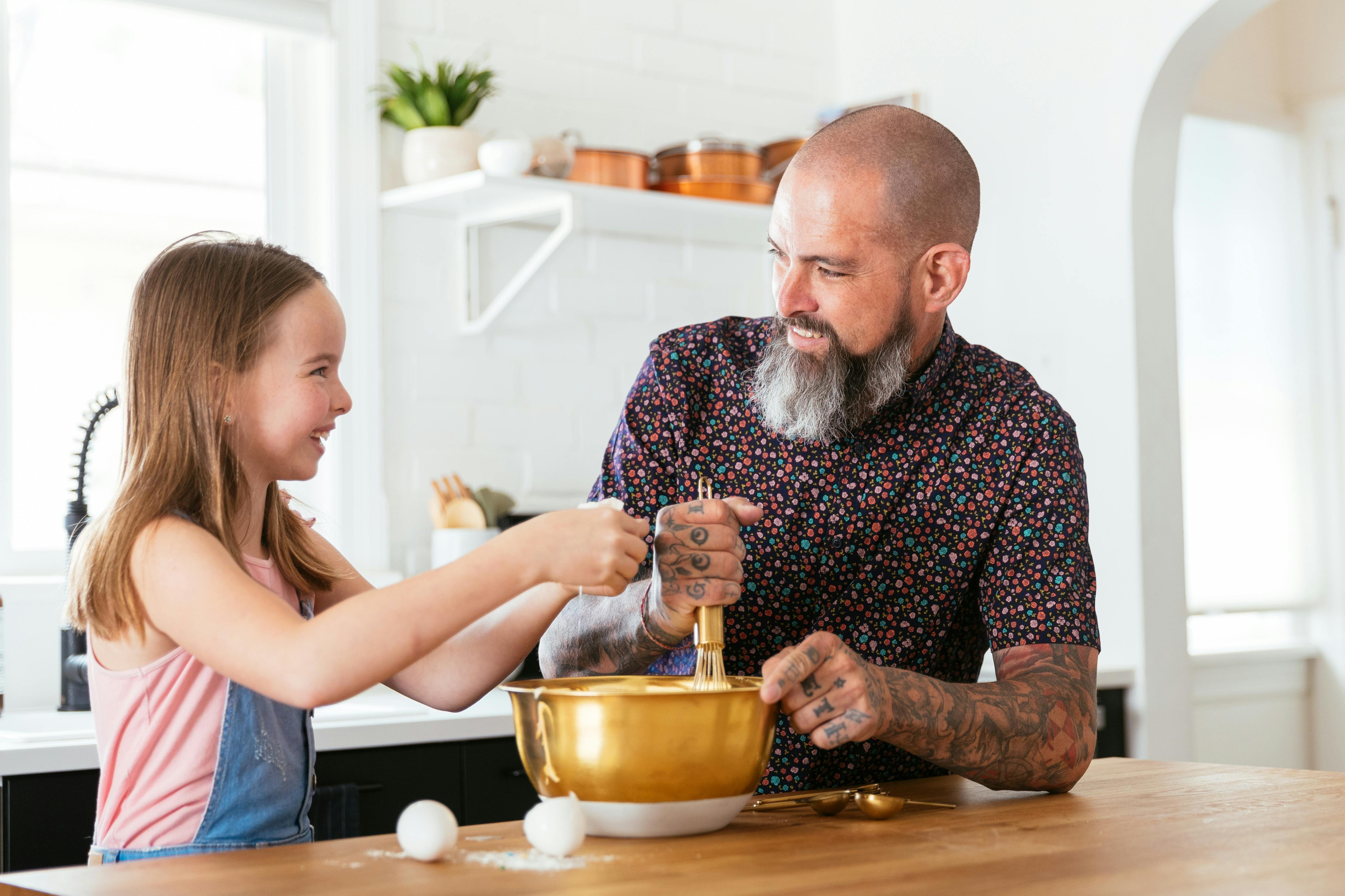 Dad smiling with daughter while baking