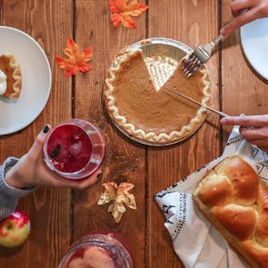Thanksgiving photoshoot of pumpkin pie and leaves on a table