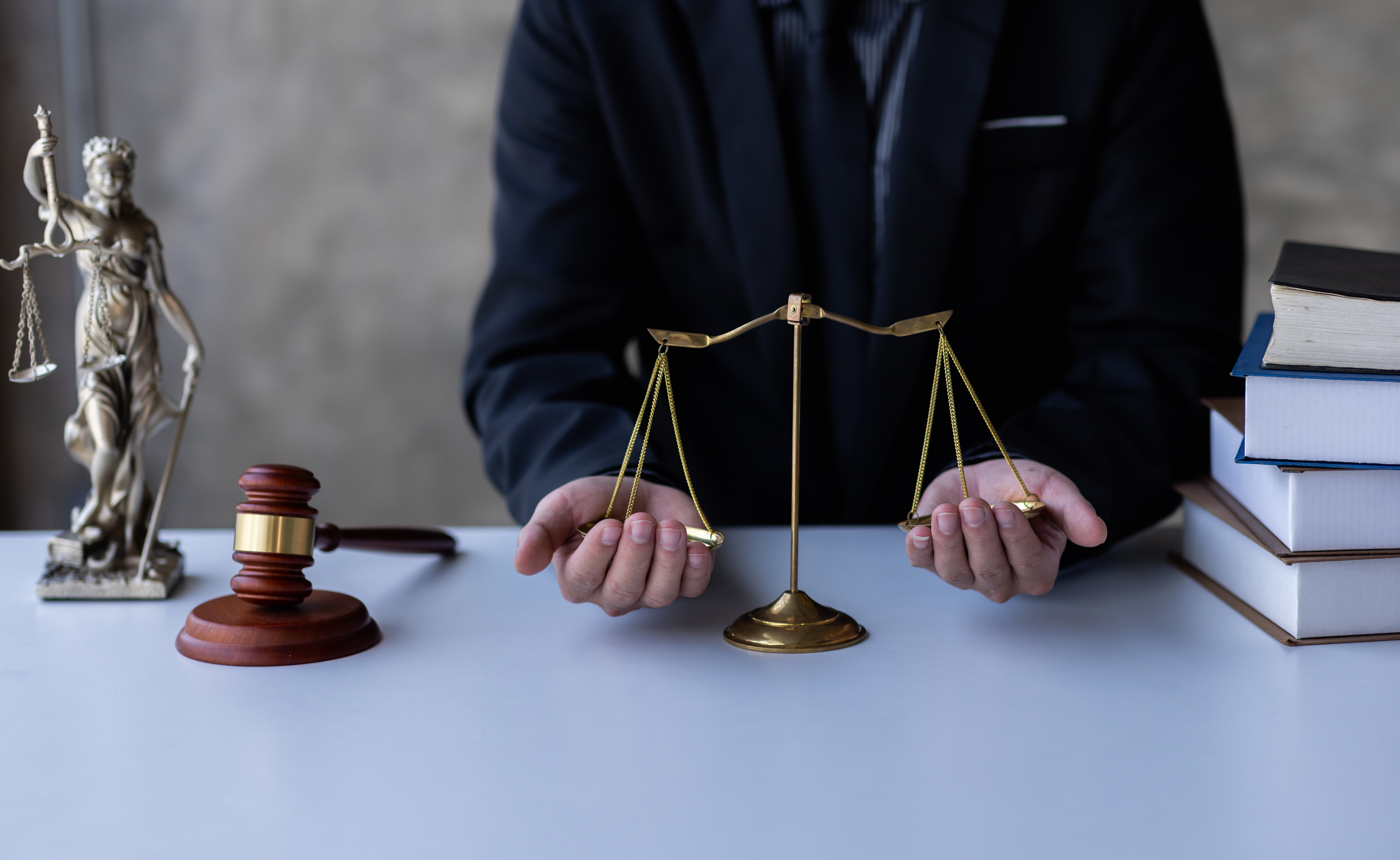 Balance de la justice tenue par deux mains.