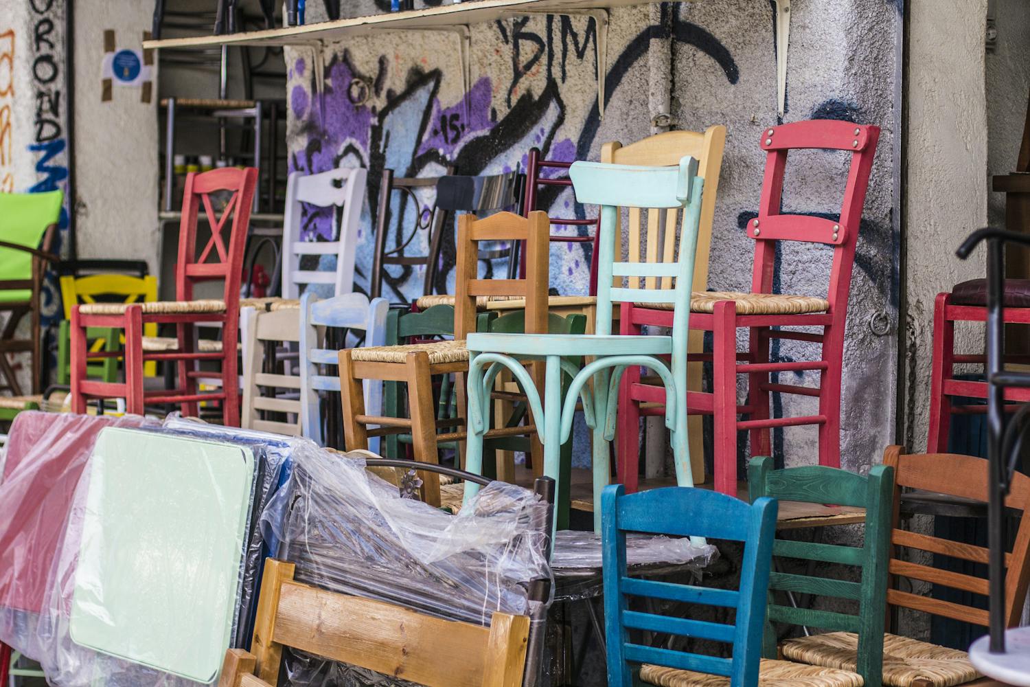 Plusieurs chaises en bois de couleurs différentes dans un garage.