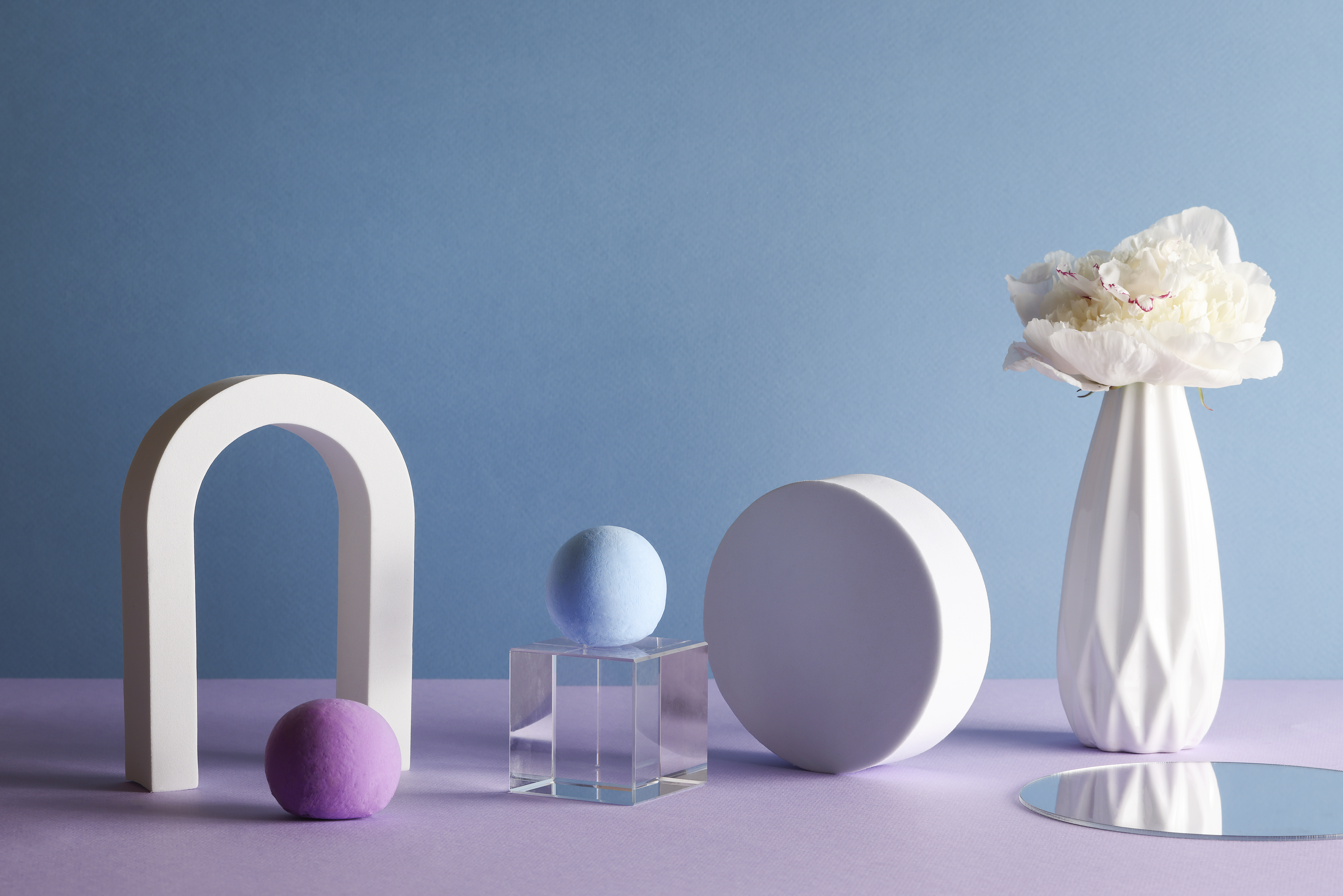 Objets de décorations blanc sur fond bleu et violet.