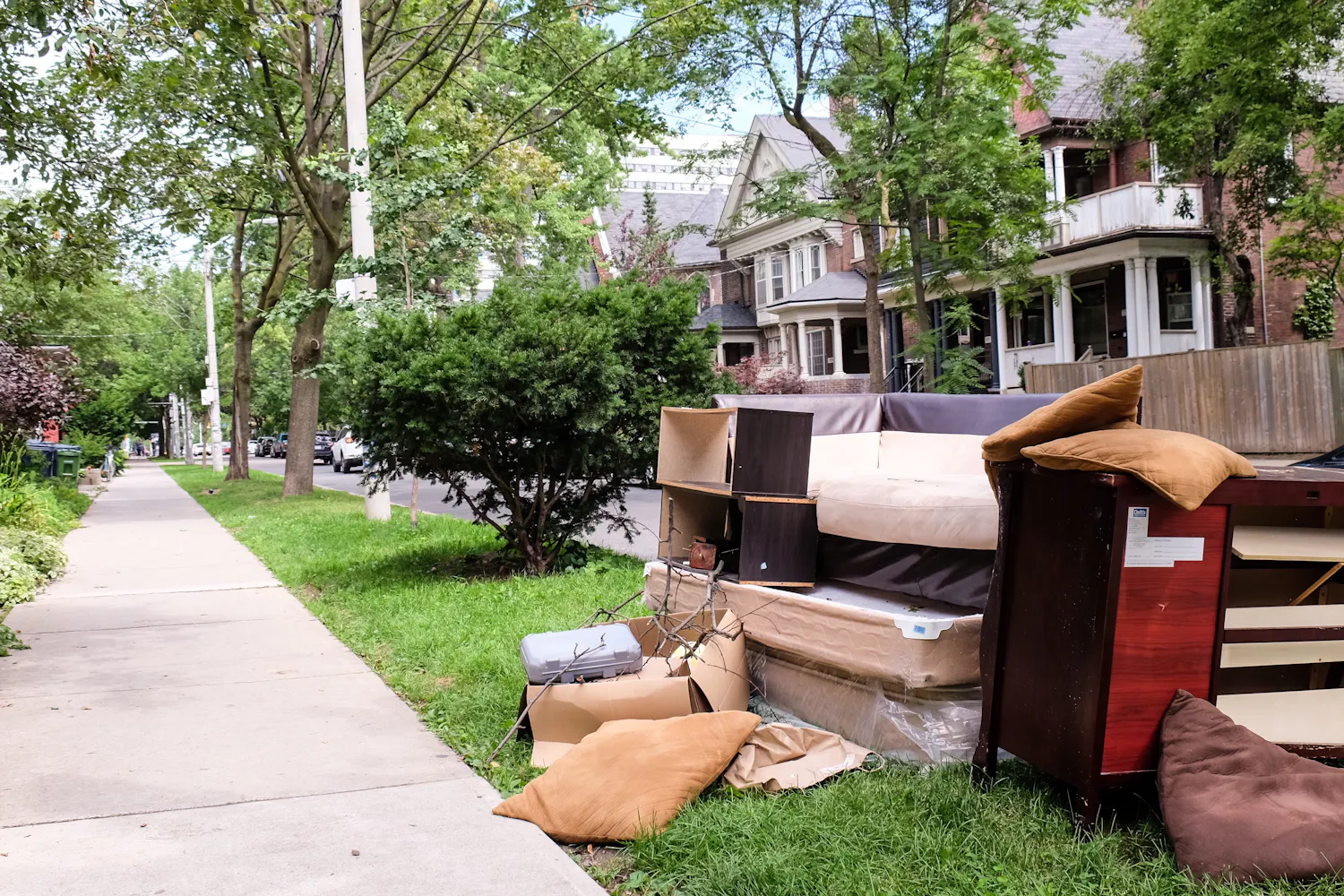 Divers encombrants empilés dans la rue devant une maison.