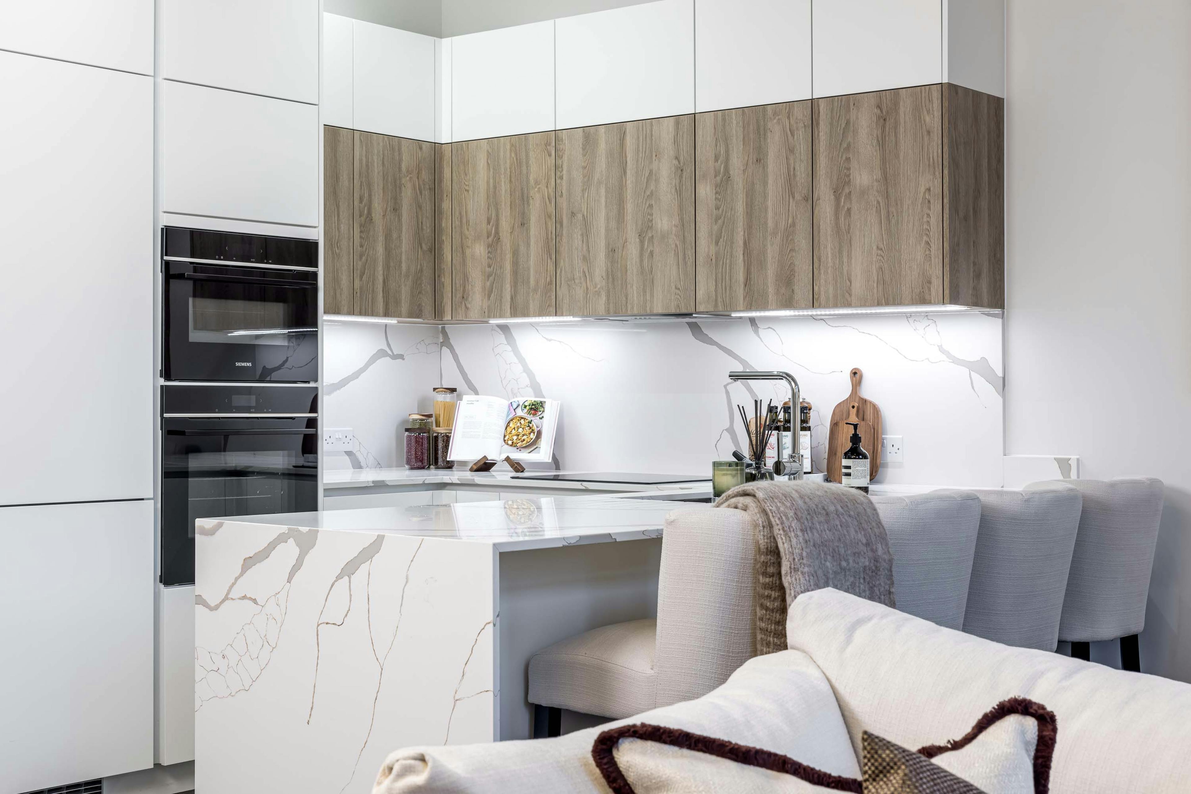 Caption: a kitchen with a marble counter top and white cabinets