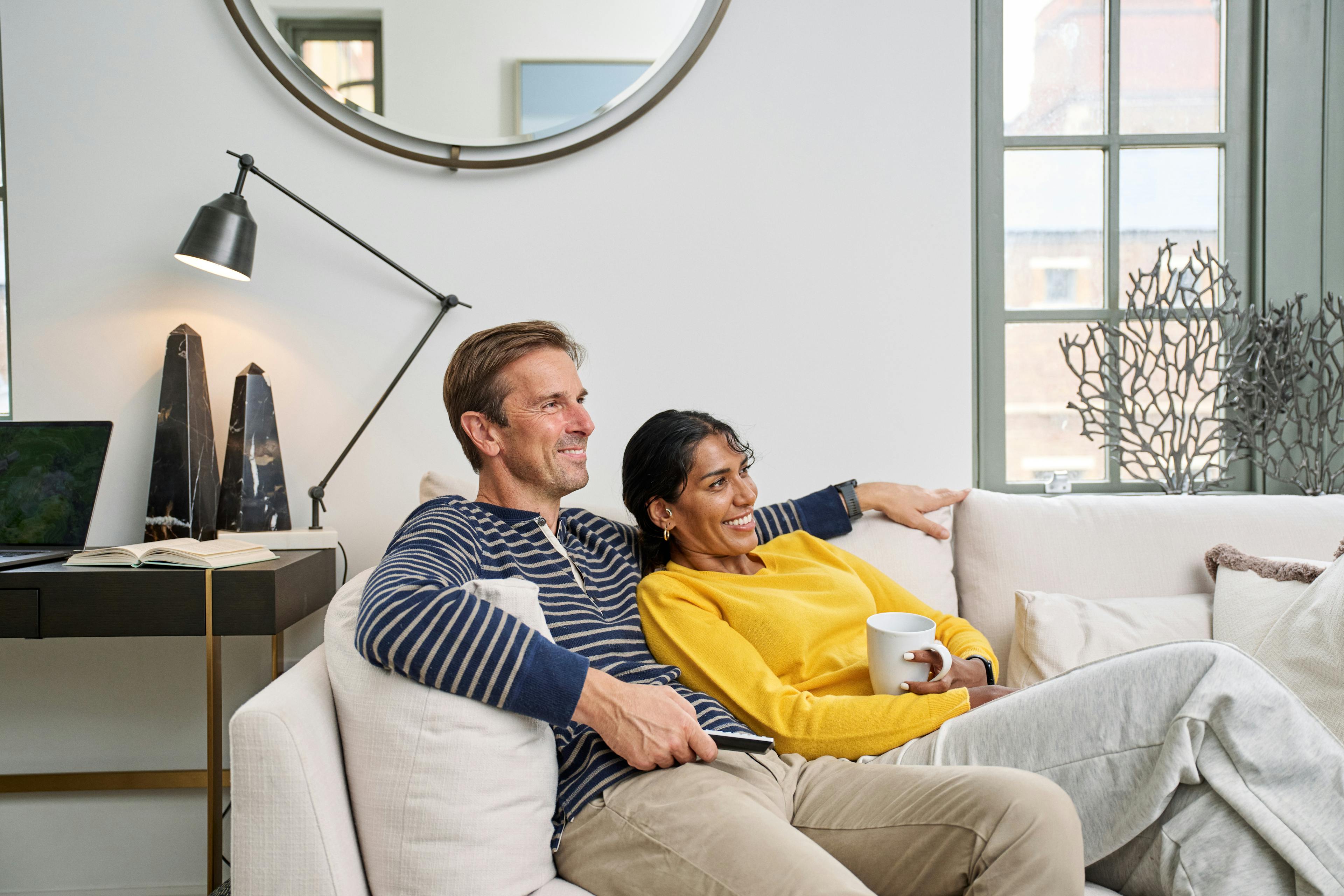 Caption: a man and a woman sitting on a couch