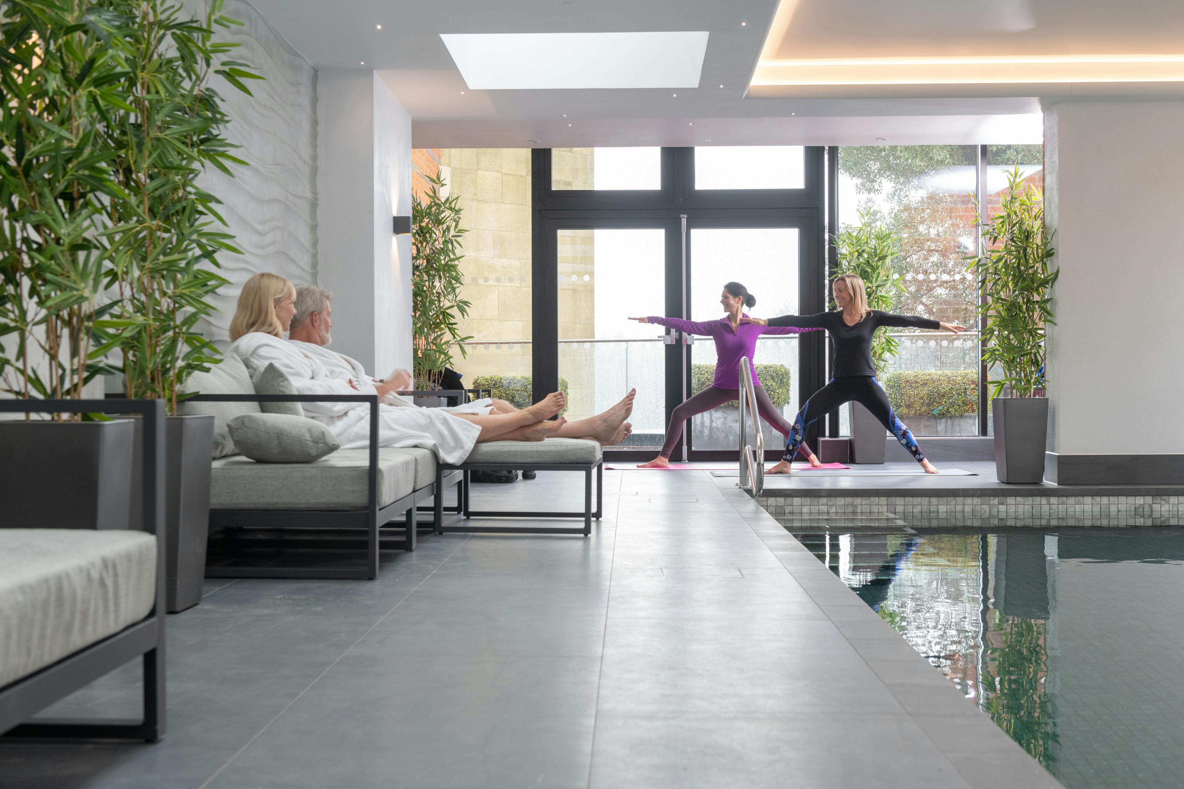 Caption: a group of people doing yoga by a pool