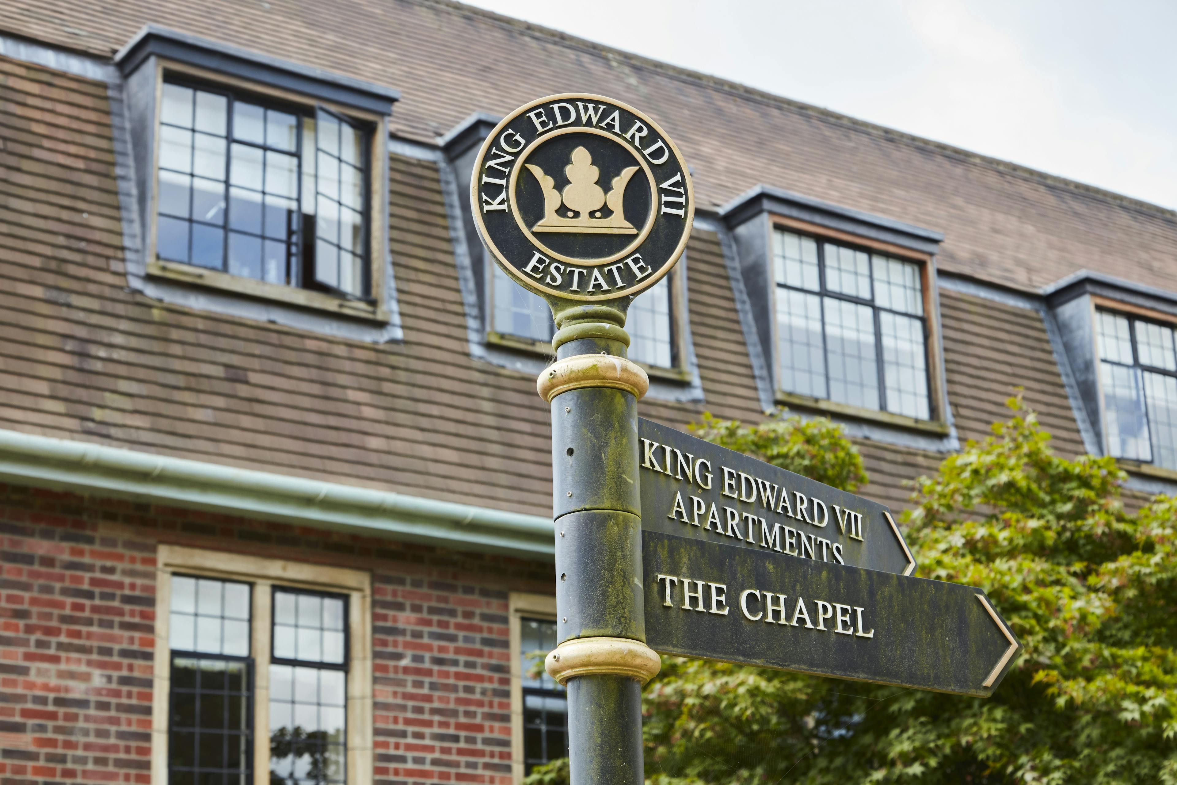 Caption: a street sign in front of a brick building