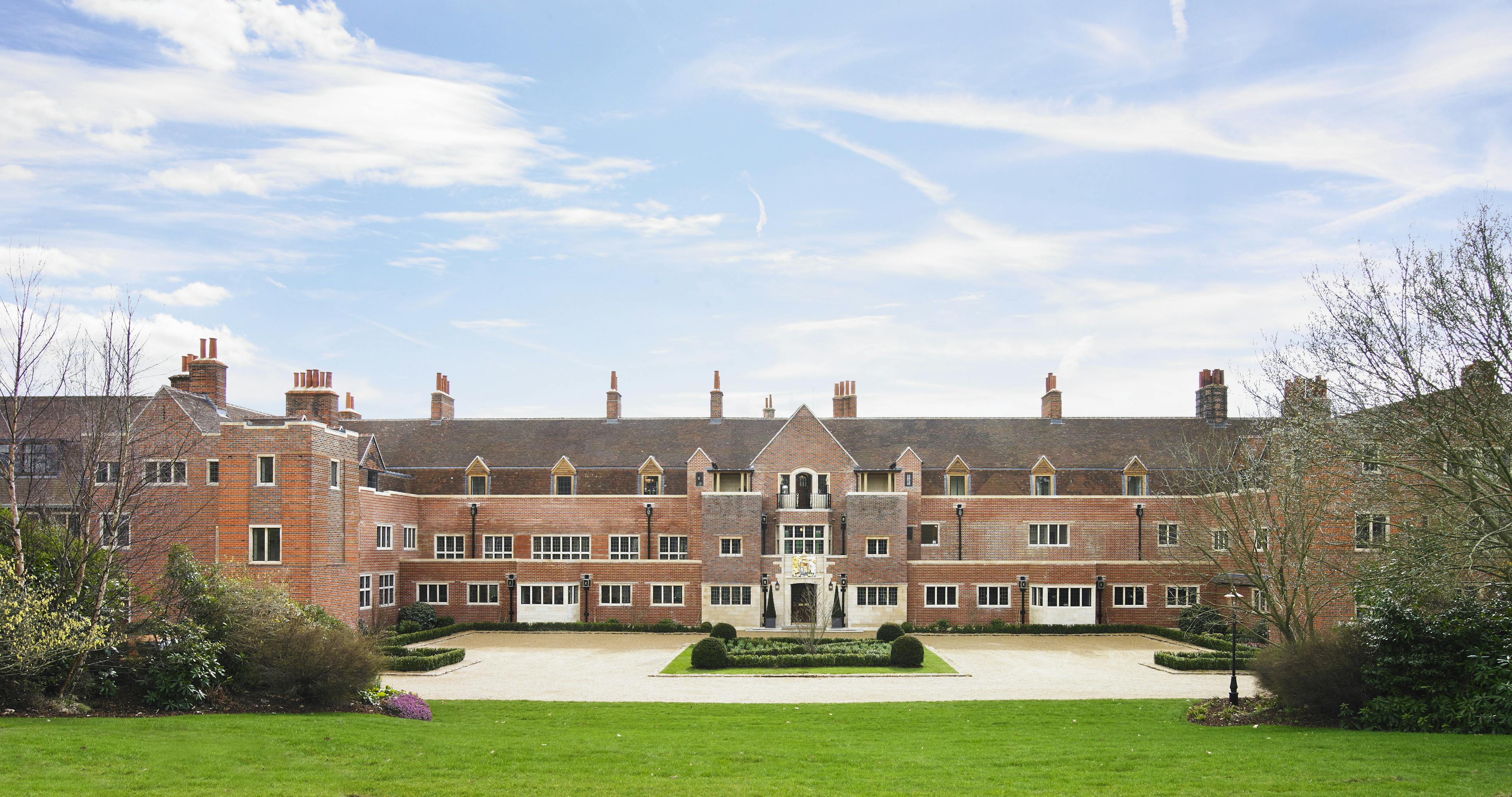 Caption: a large brick building with a lawn in front of it