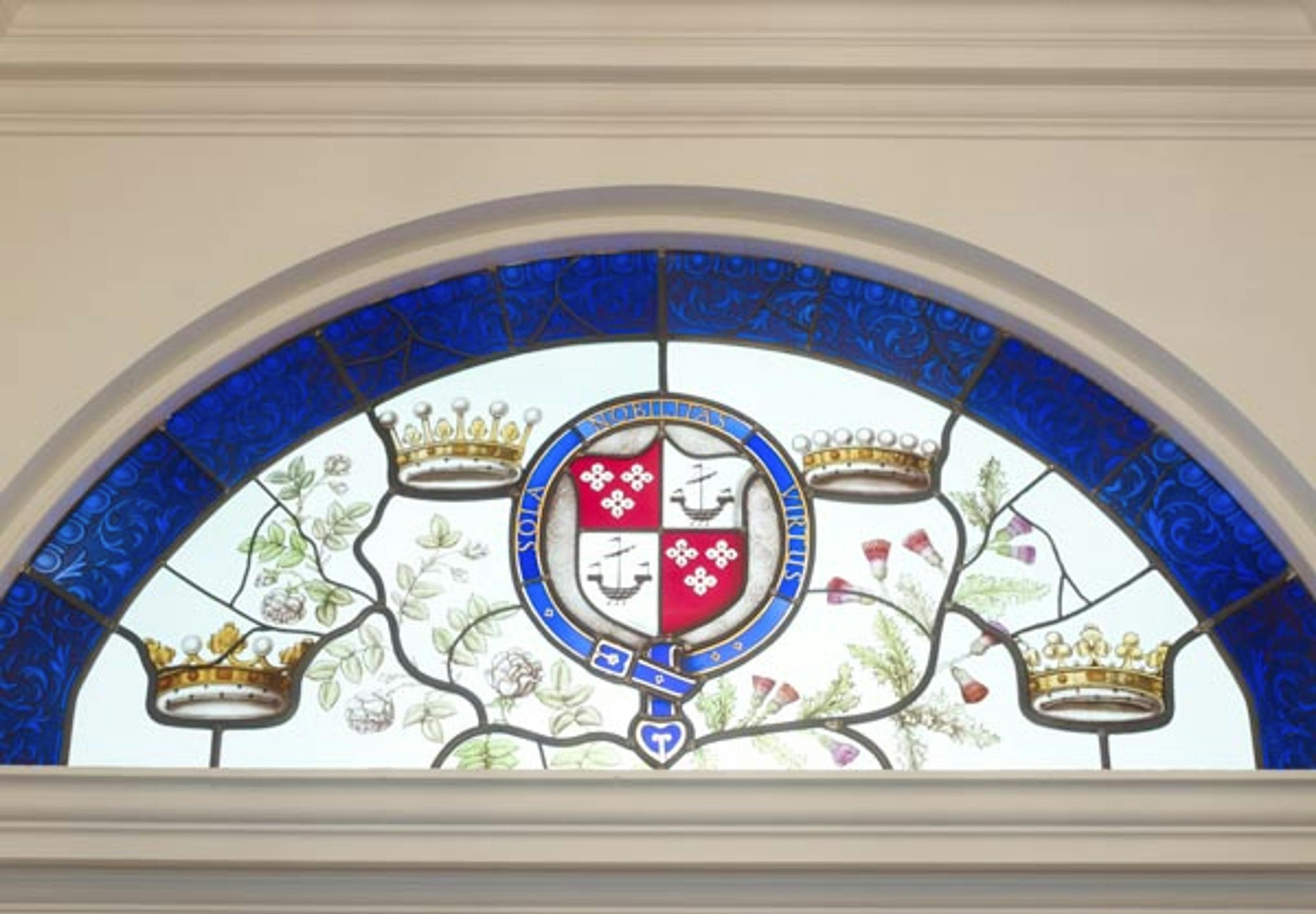 Caption: a stained glass window with a coat of arms on it