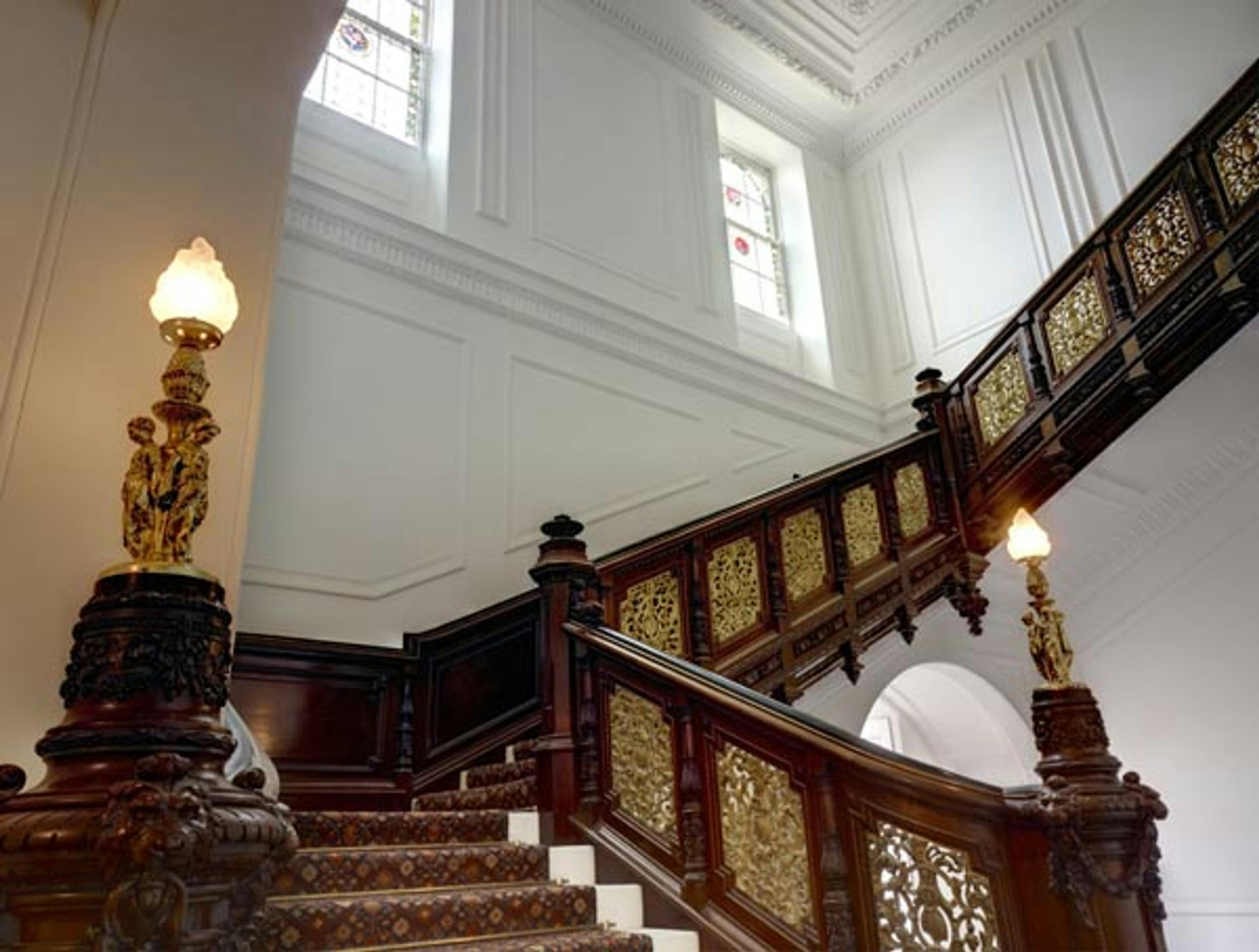 Caption: a staircase in a building with a clock on the wall