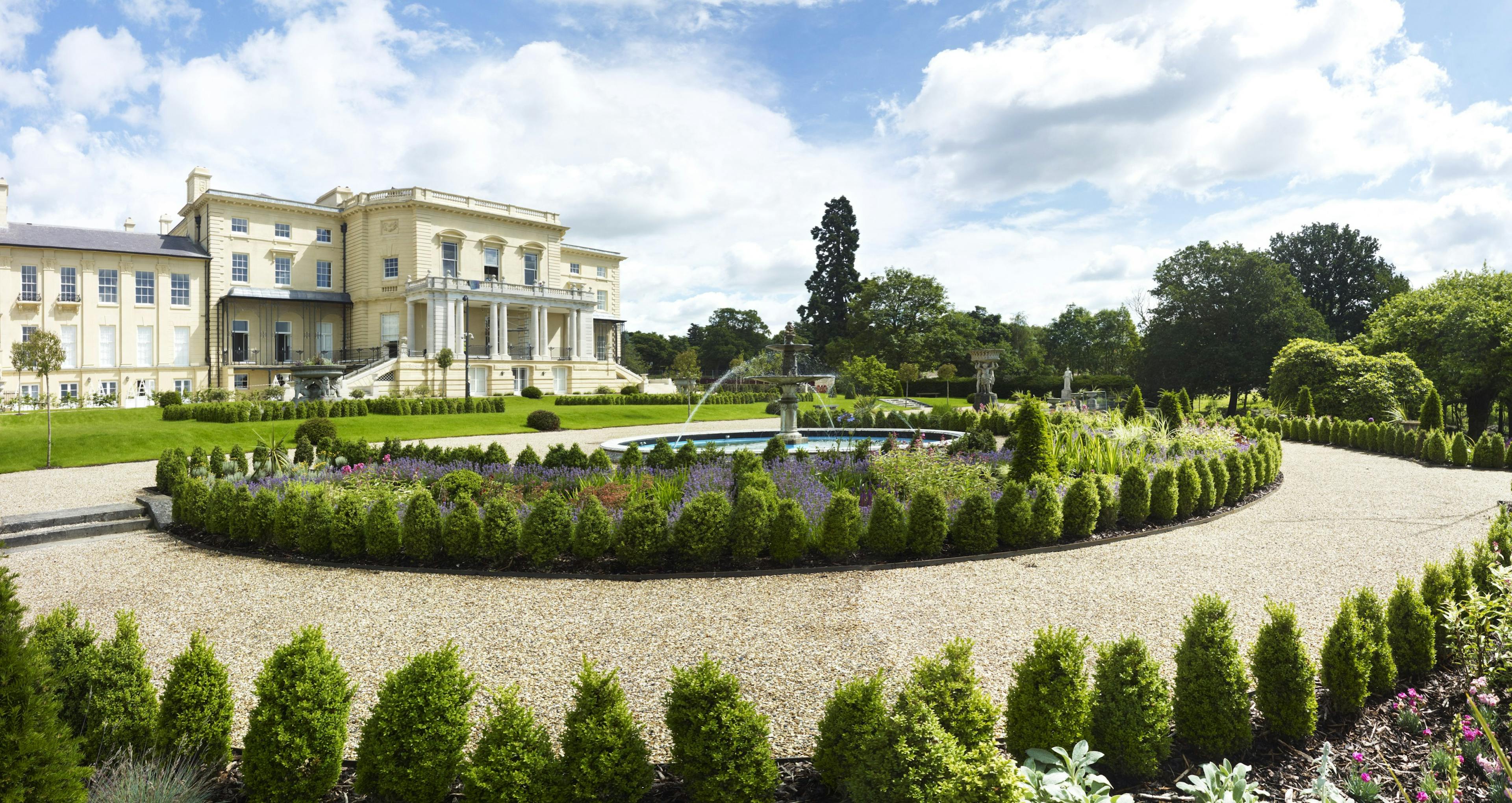Caption: a circular garden in front of a large house