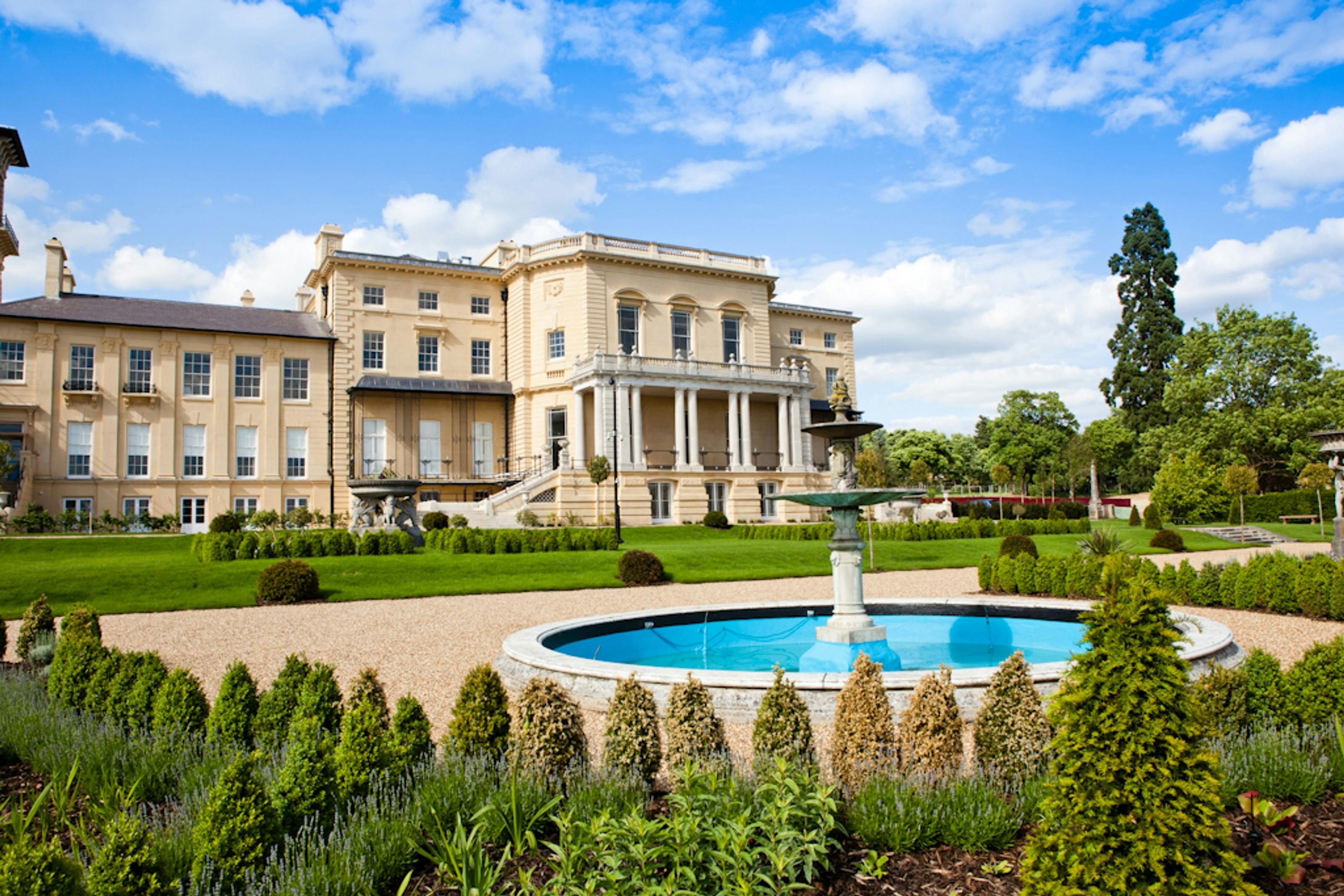 Caption: a large building with a fountain in front of it