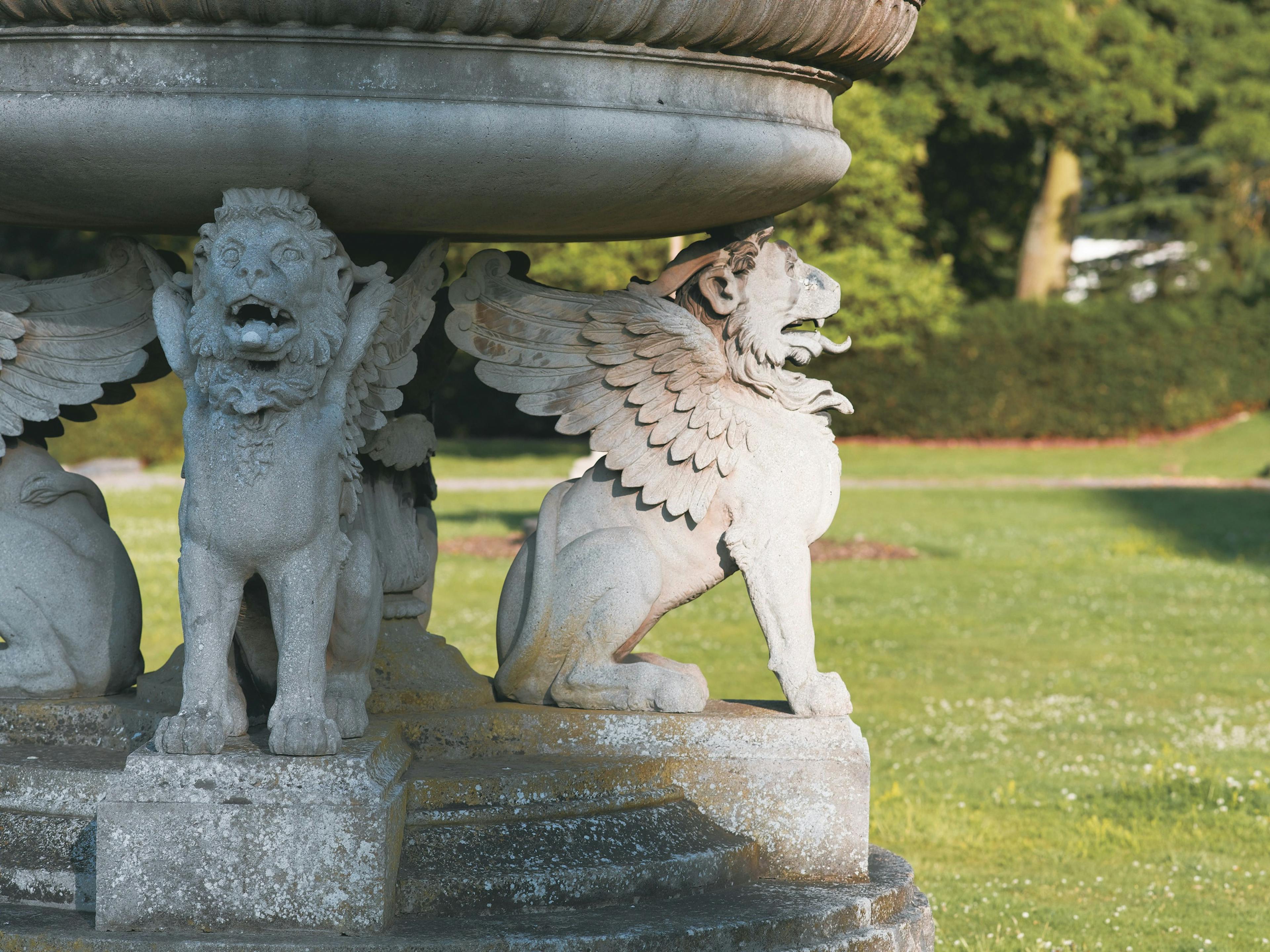 Caption: a statue of a lion and a dog in a park