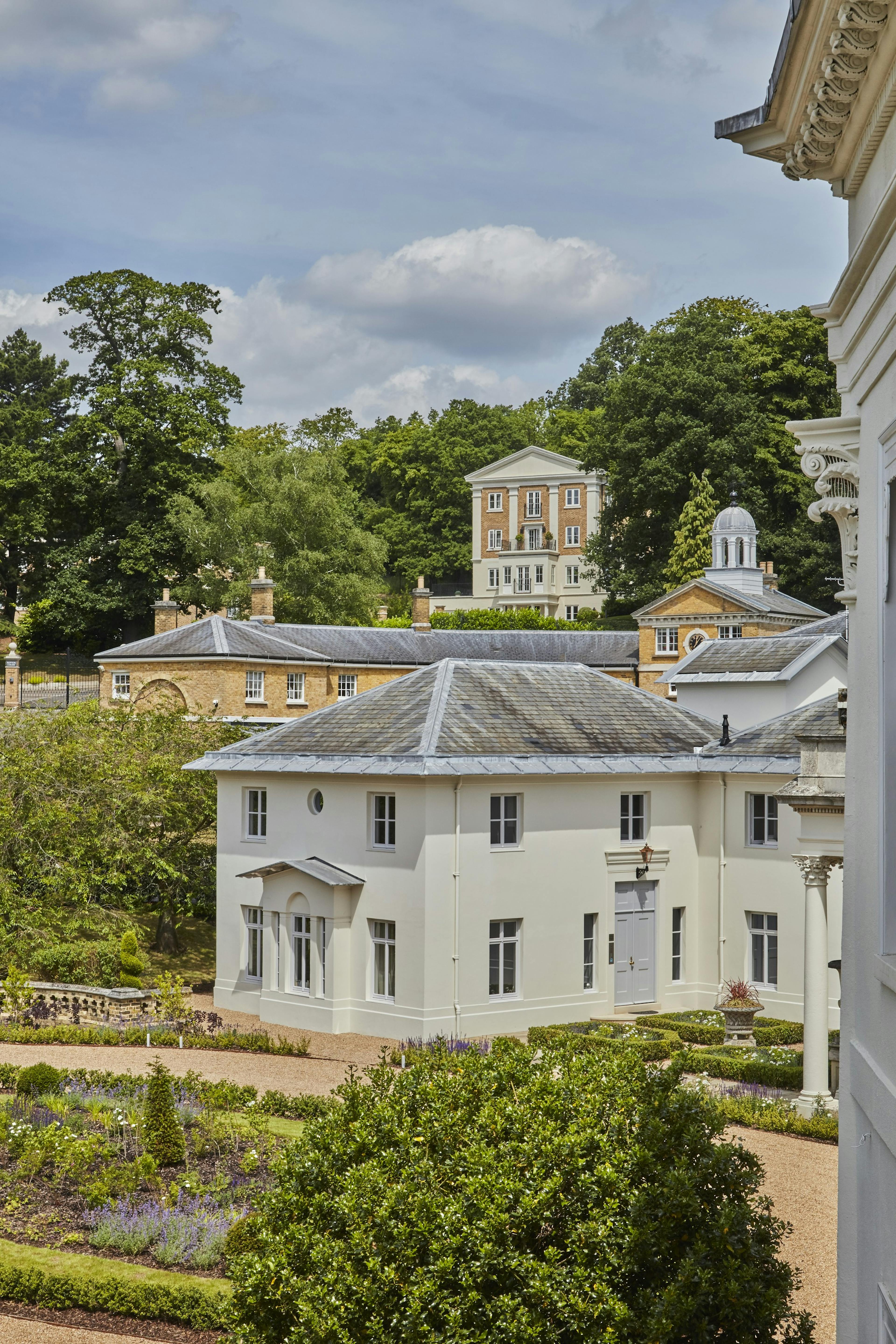 Caption: a large white building with a clock on the front of it