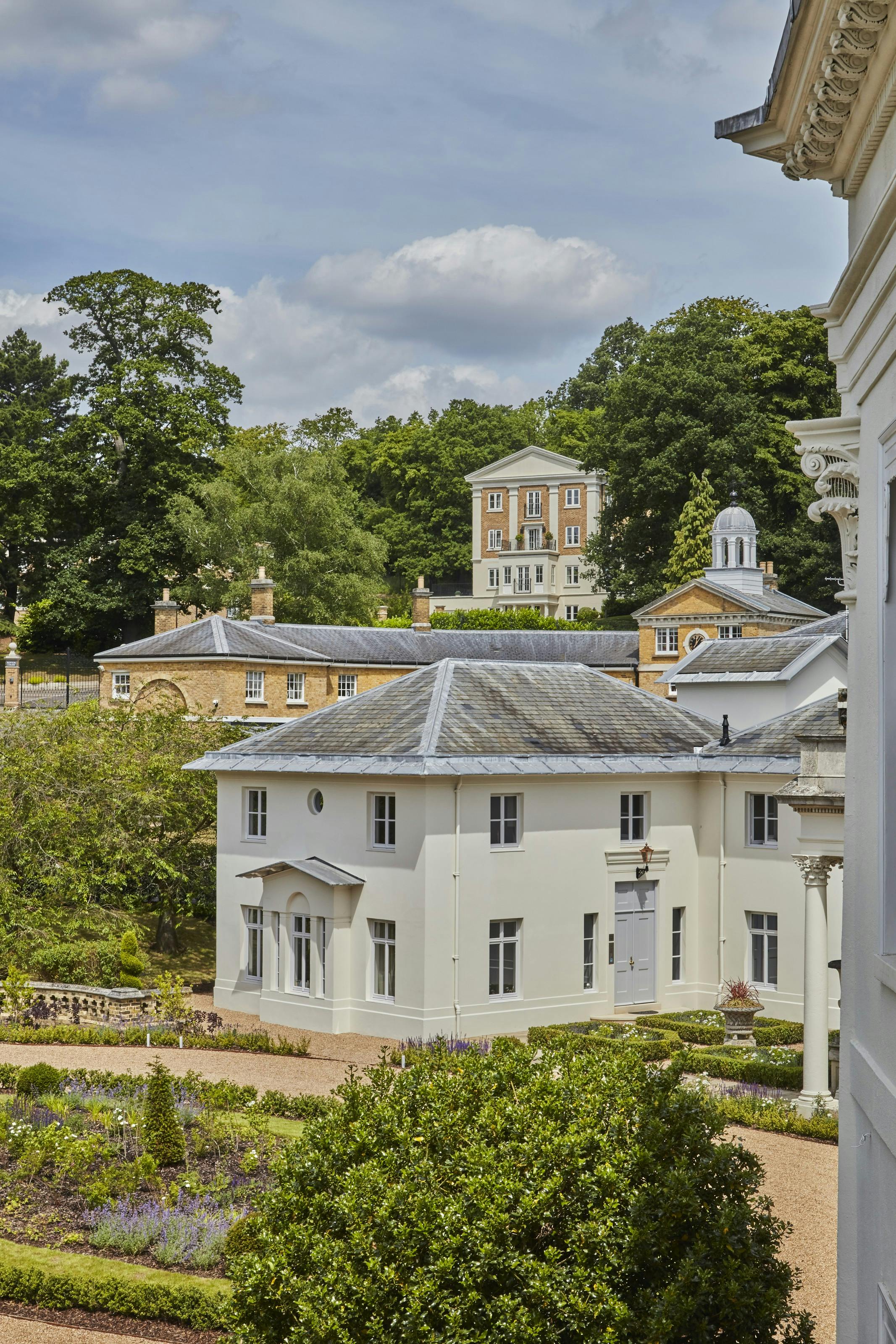 Caption: a large white building with a clock on the front of it