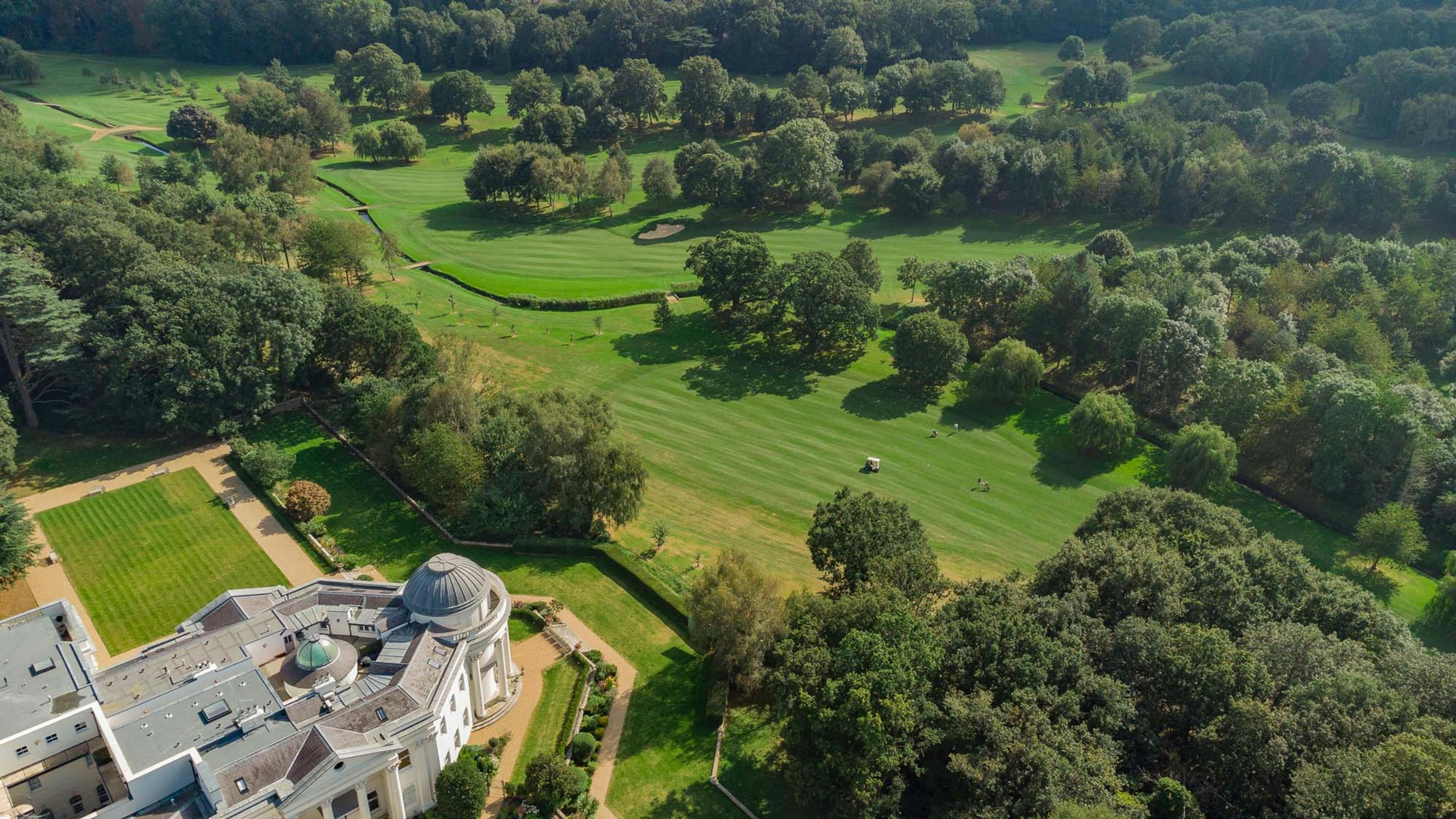 Caption: an aerial view of a golf course surrounded by trees