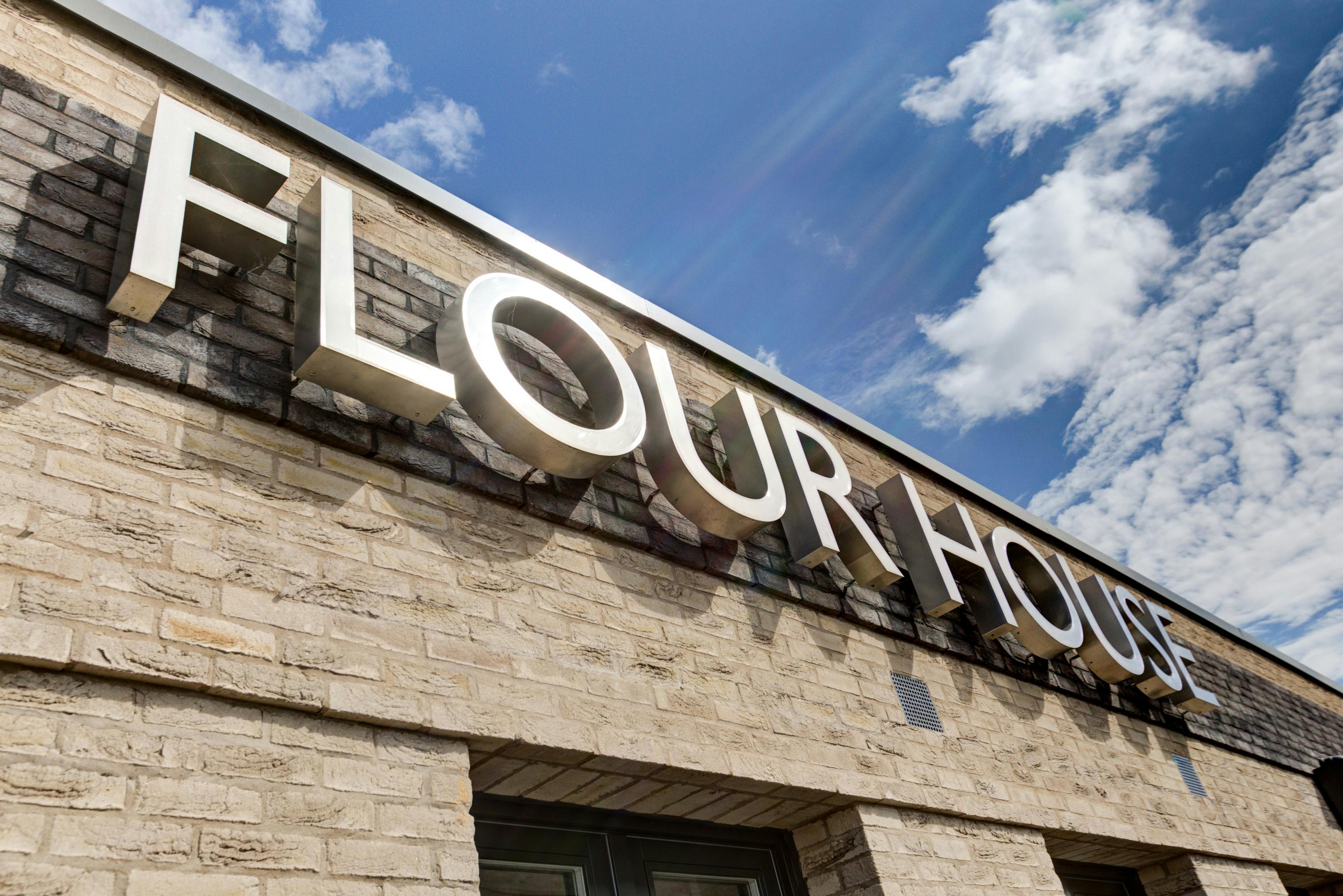 Caption: a sign on the side of a building that says flour house