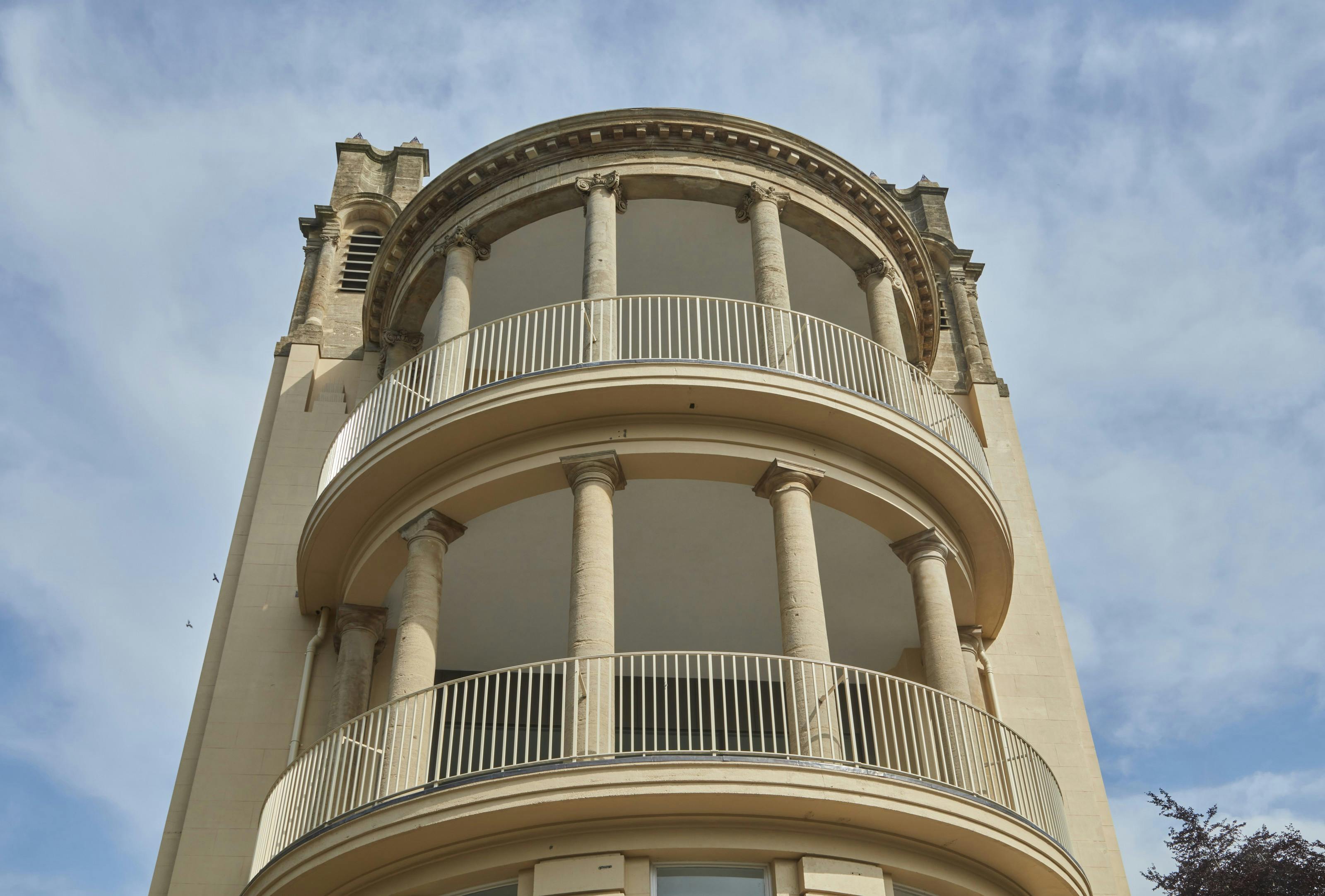 Caption: a tall building with a clock on the top of it