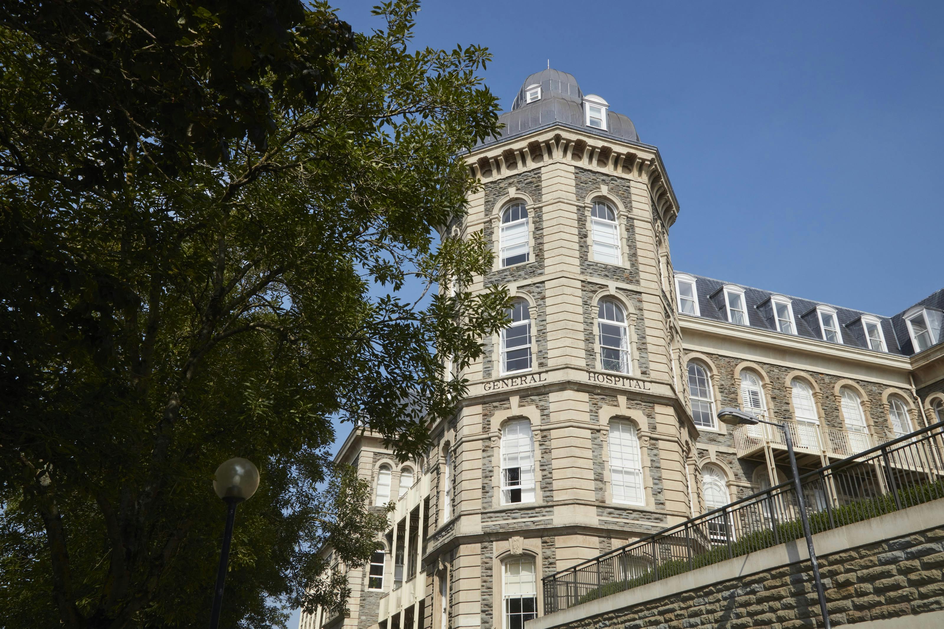 Caption: a tall building with a clock on the top of it