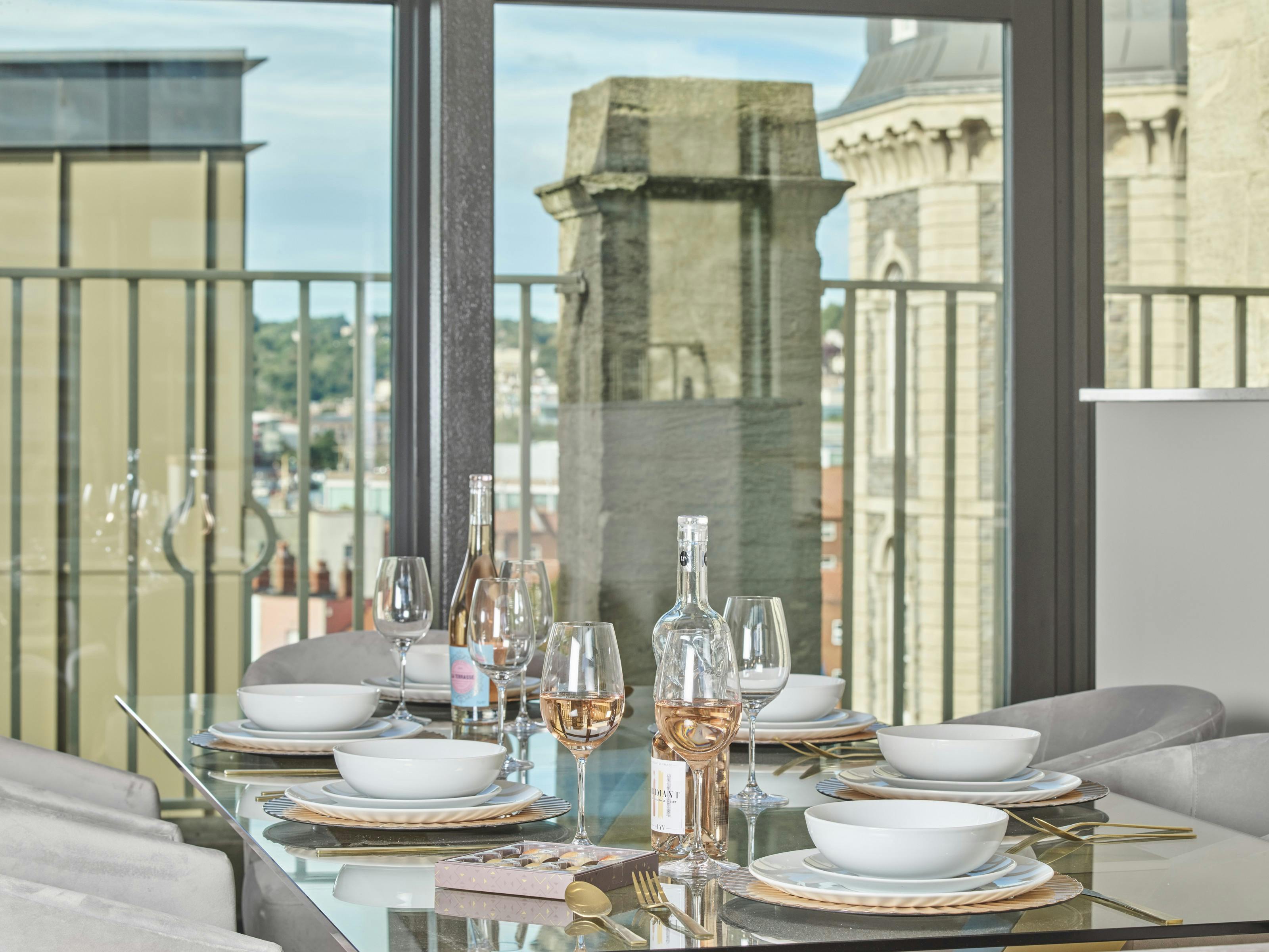 Caption: a glass table with plates and glasses on it