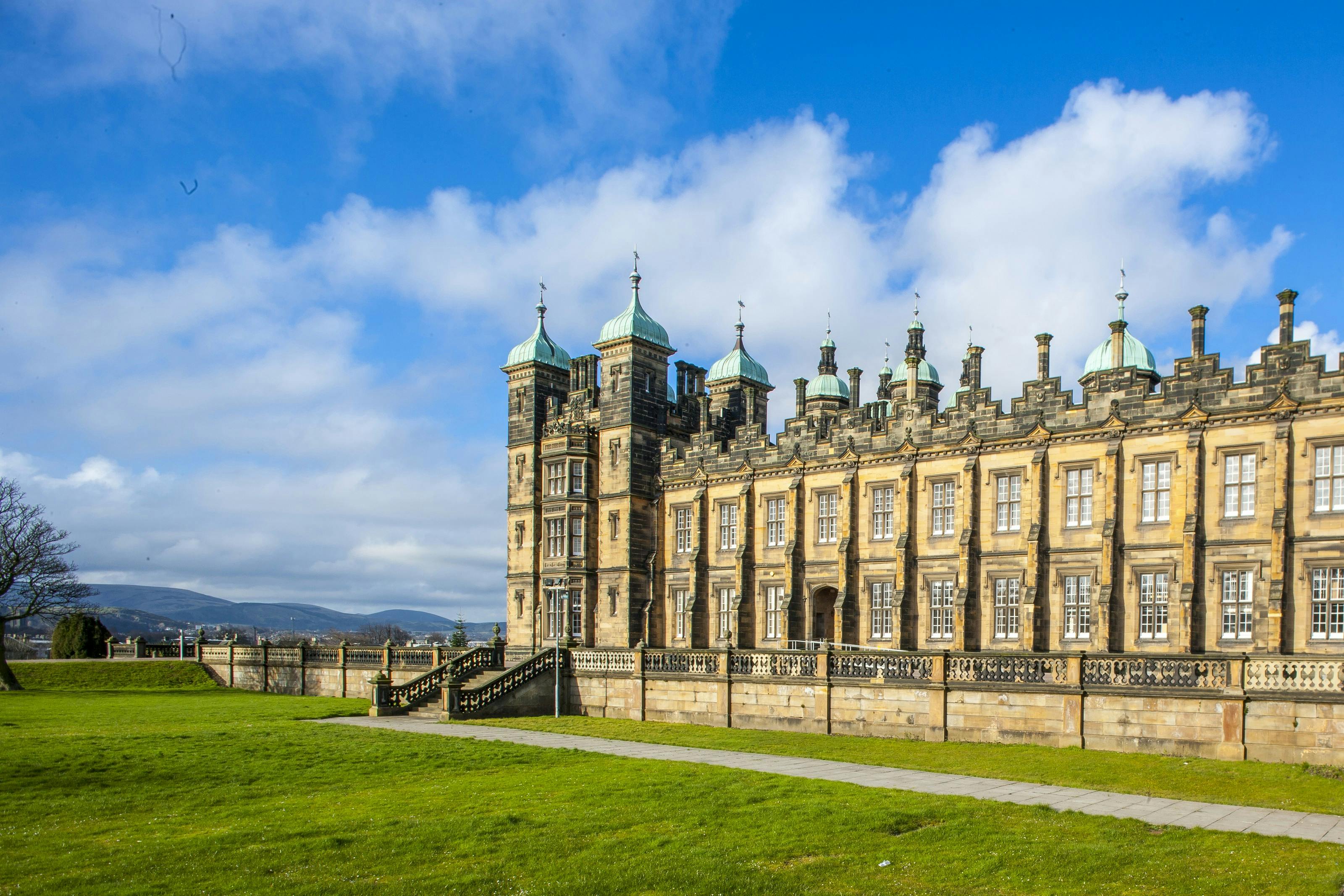 Caption: a large building sitting on top of a lush green field