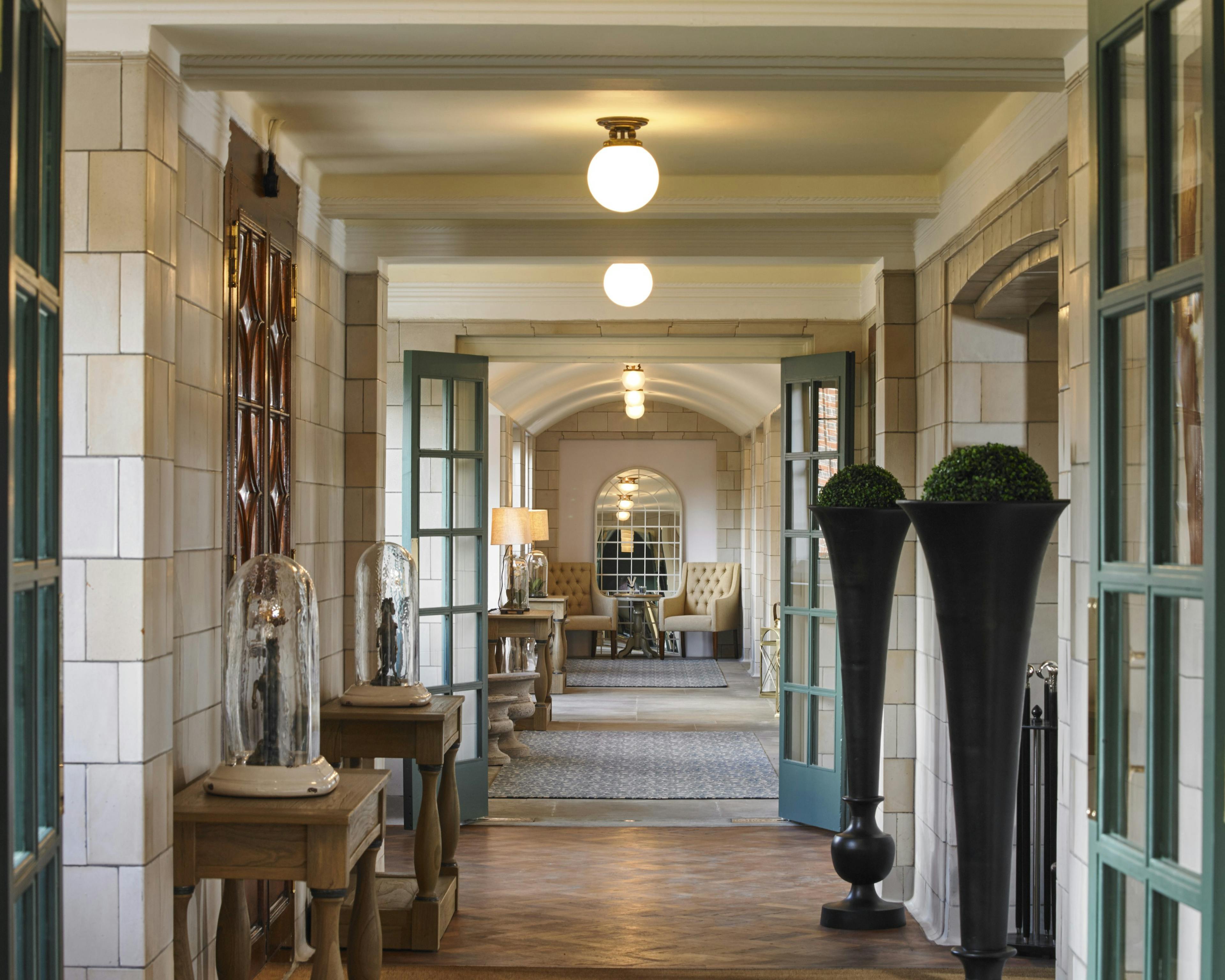 Caption: a long hallway with a vase on the floor