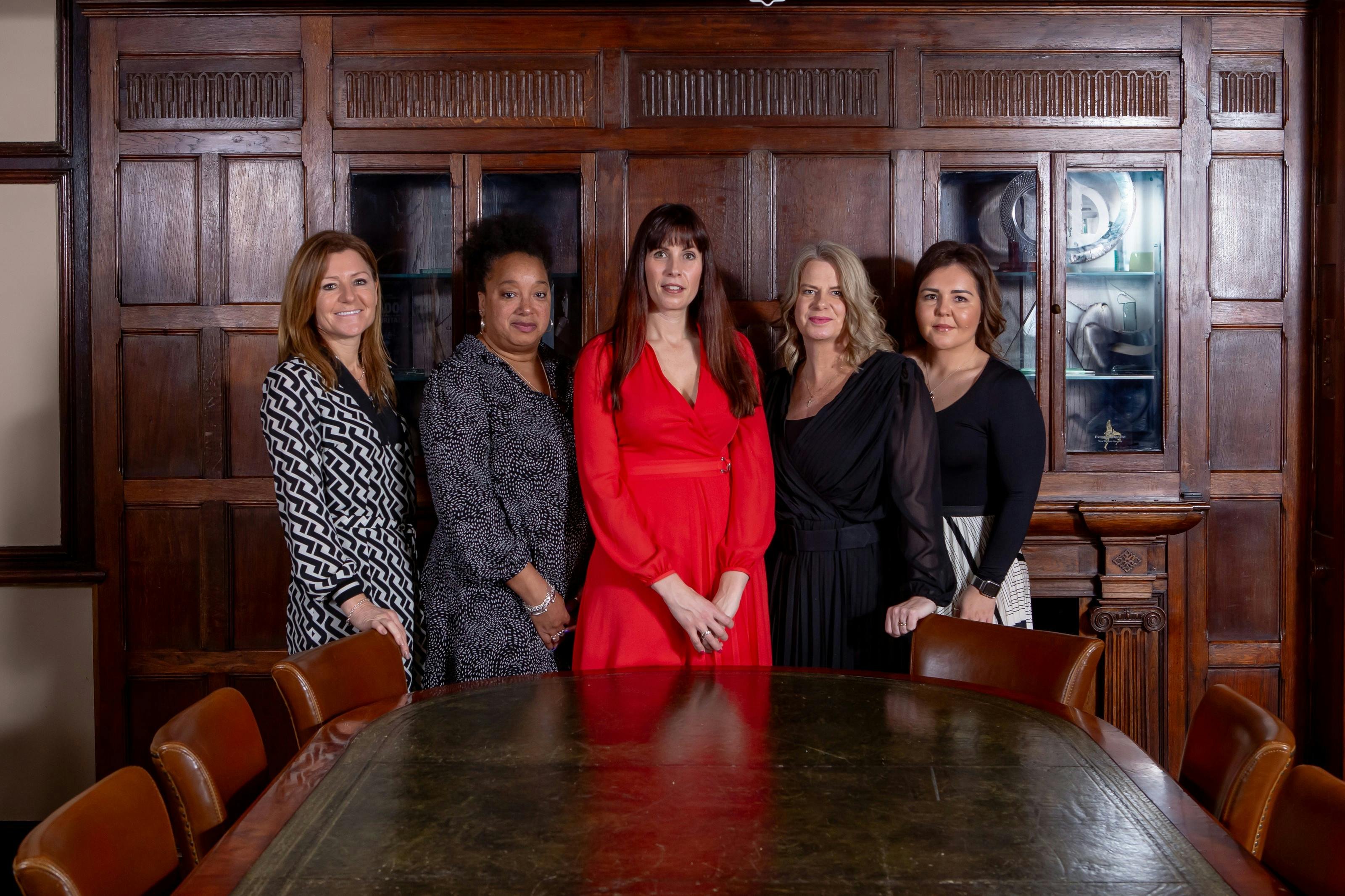 Caption: a group of women standing next to each other in front of a table