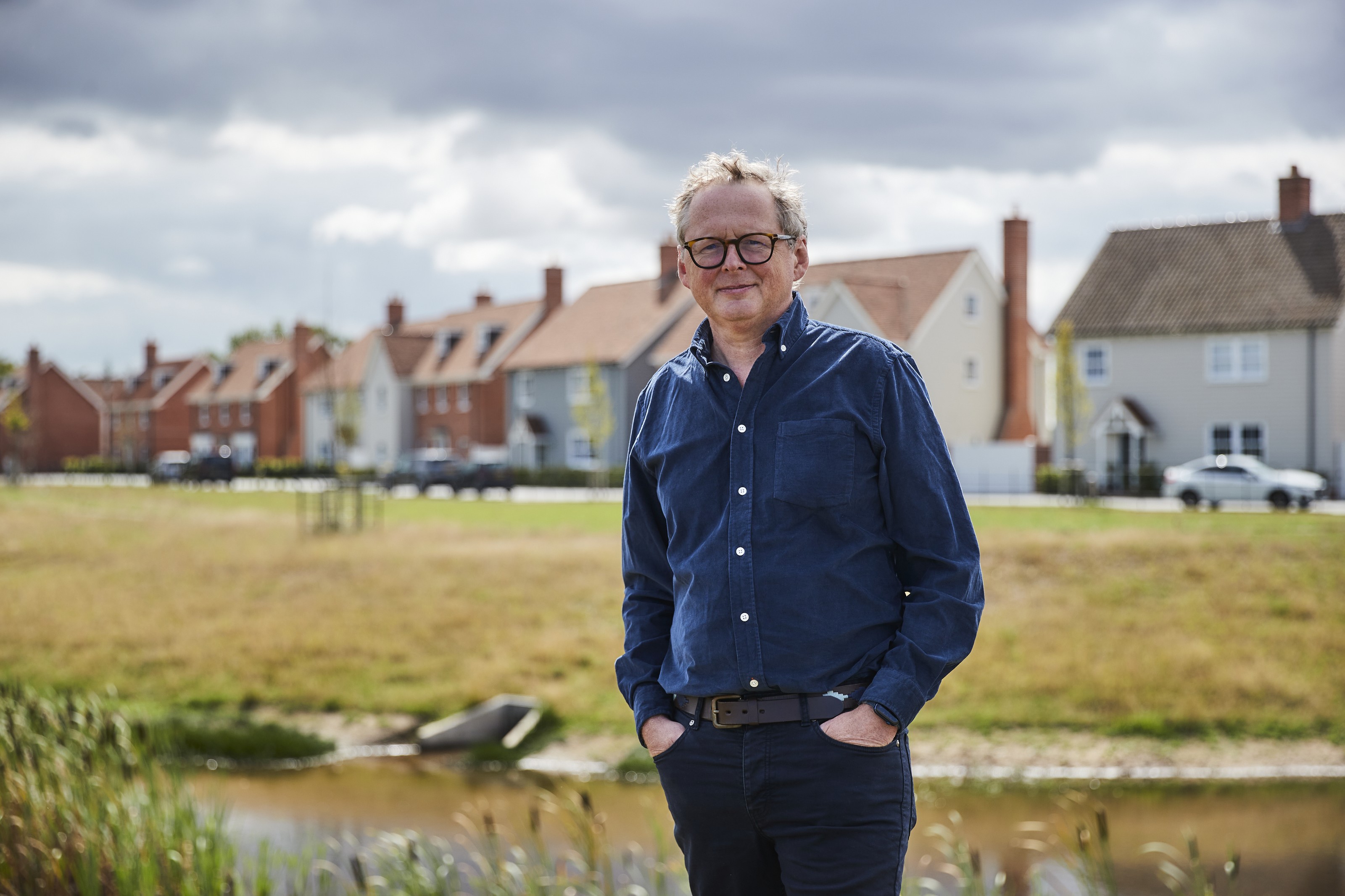 Caption: a man standing in front of a body of water