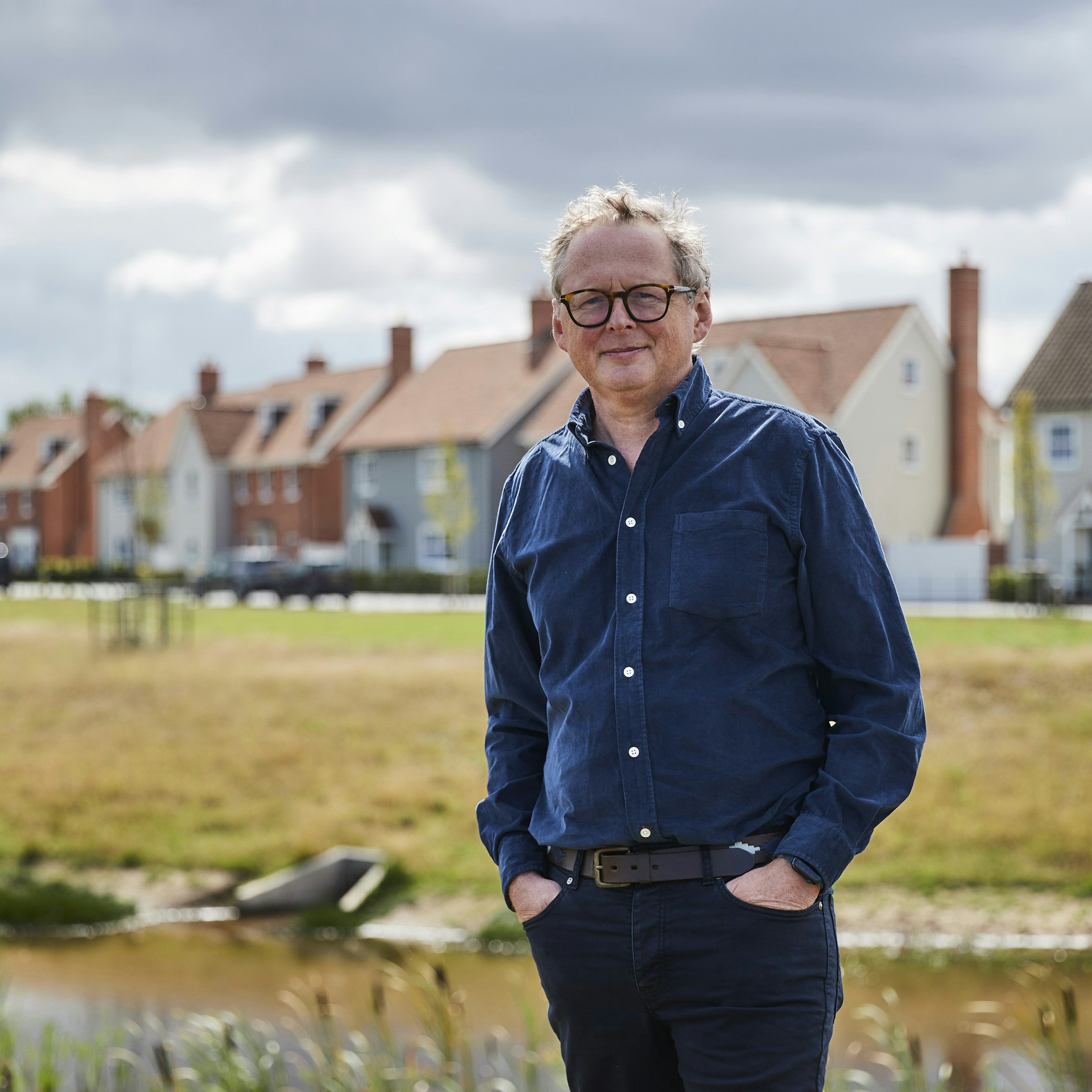 Caption: a man standing in front of a body of water