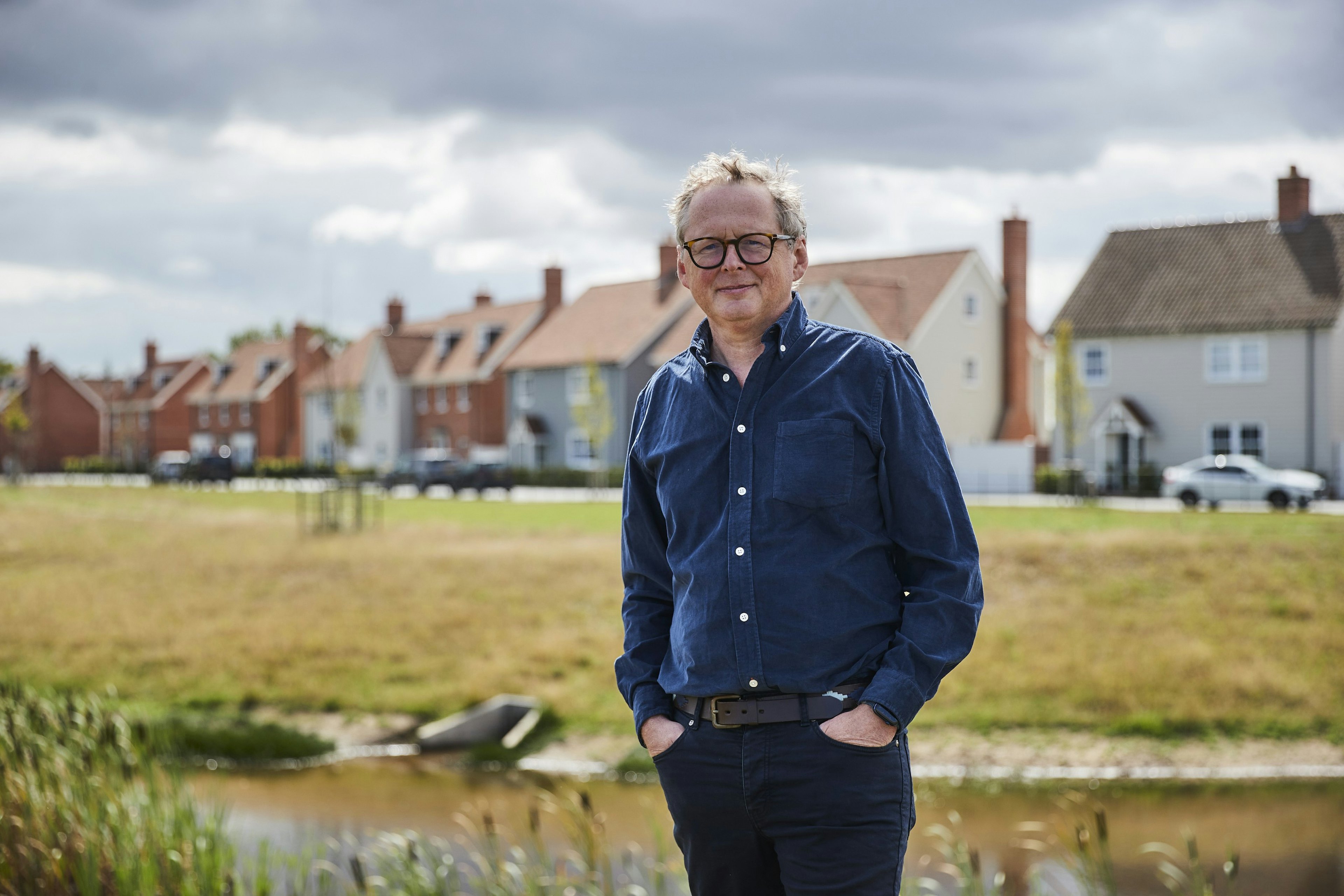 Caption: a man standing in front of a body of water