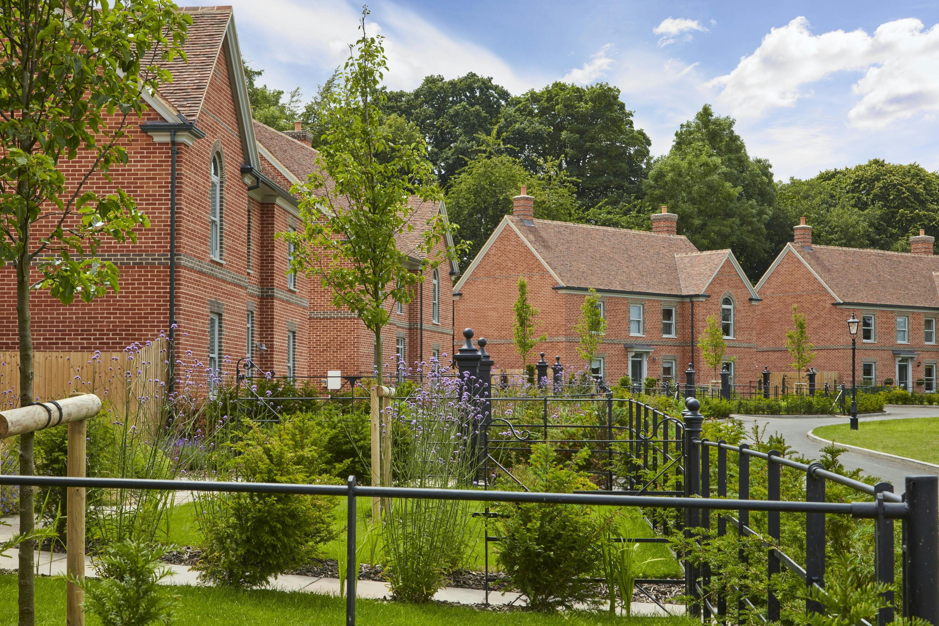 Caption: a large brick building with a garden in front of it